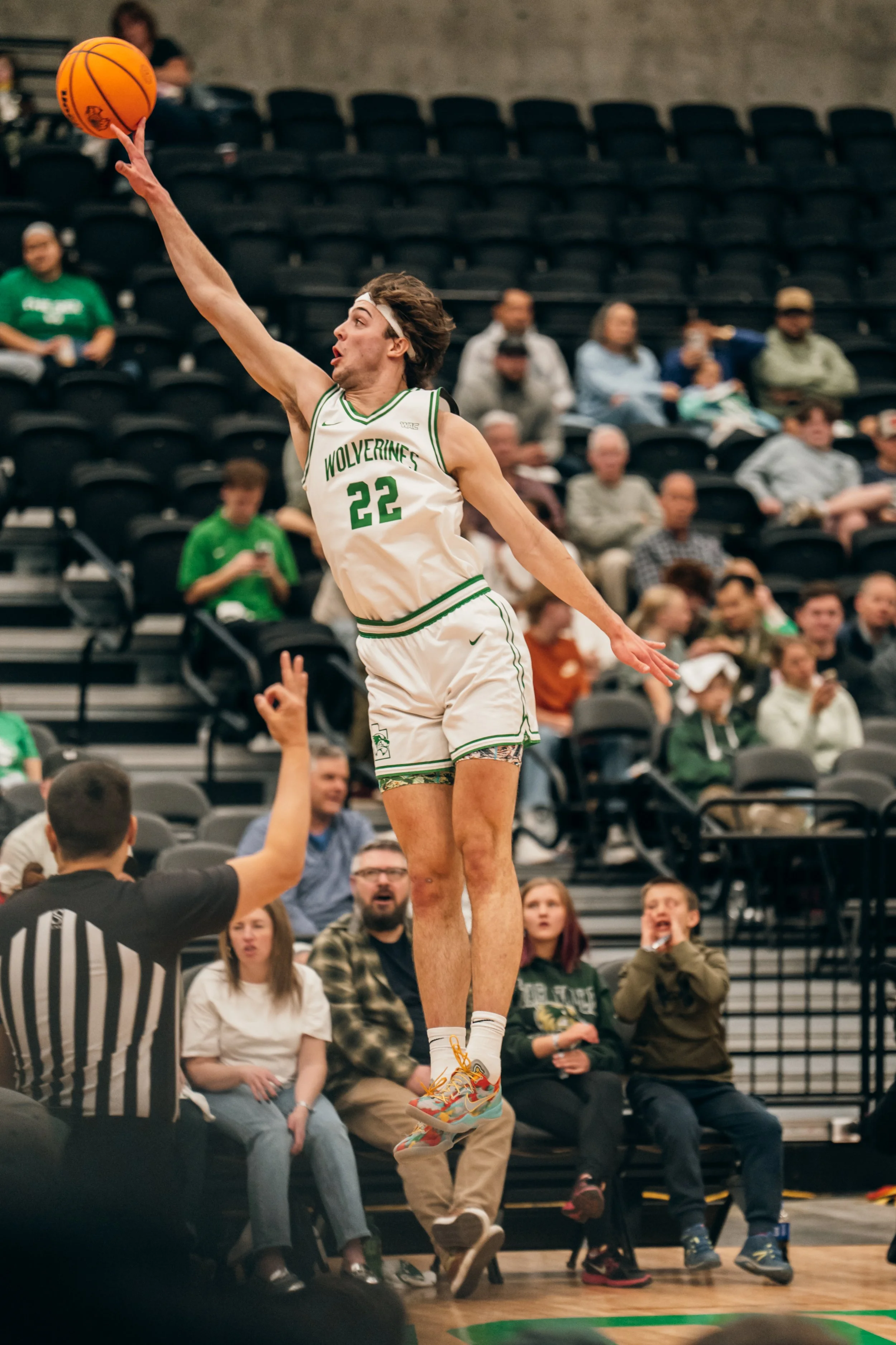UVU Men's Basketball player leaps out of bounds in an attempt to rescue the ball. 