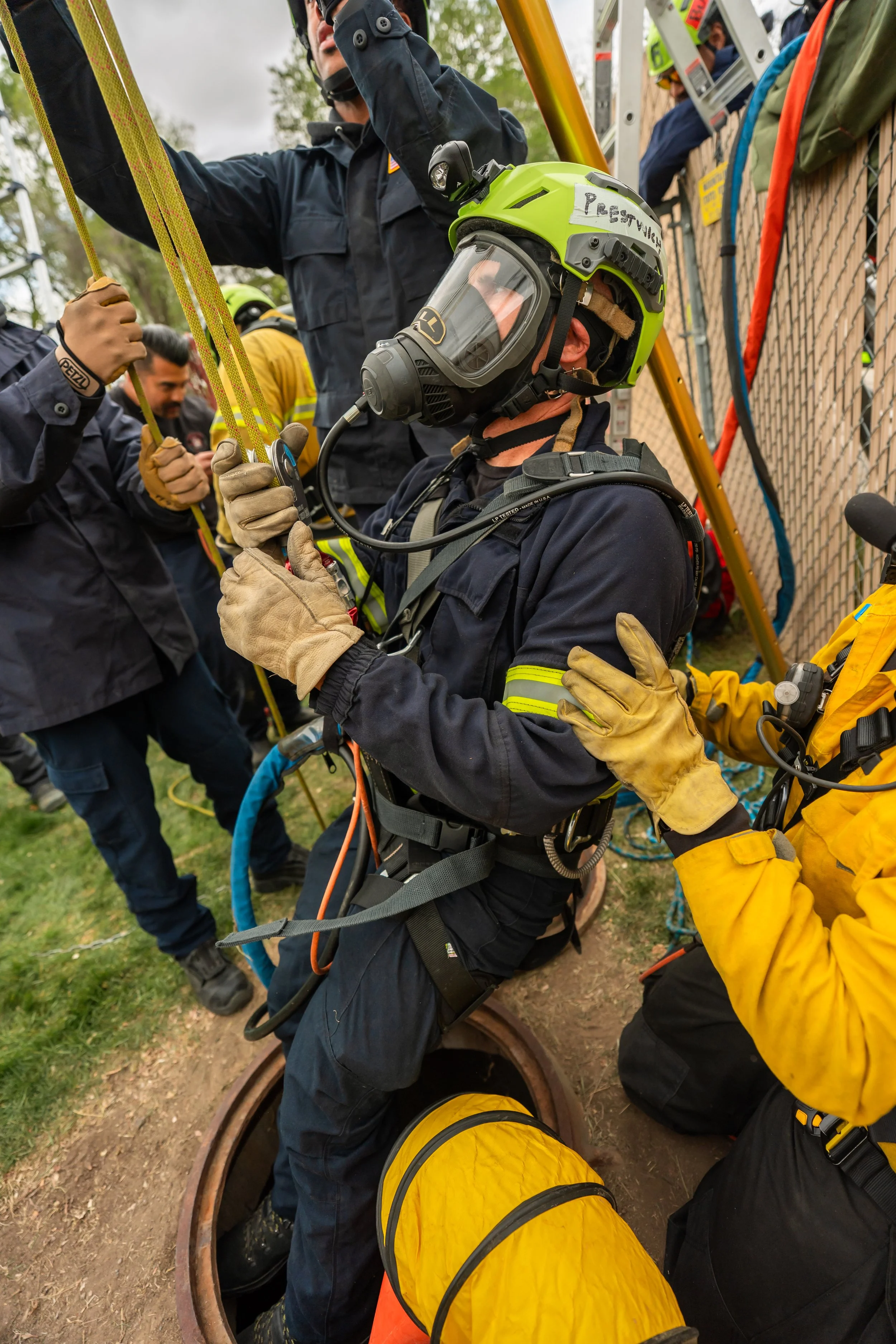 A firefighter gets hoisted out of a sewer.