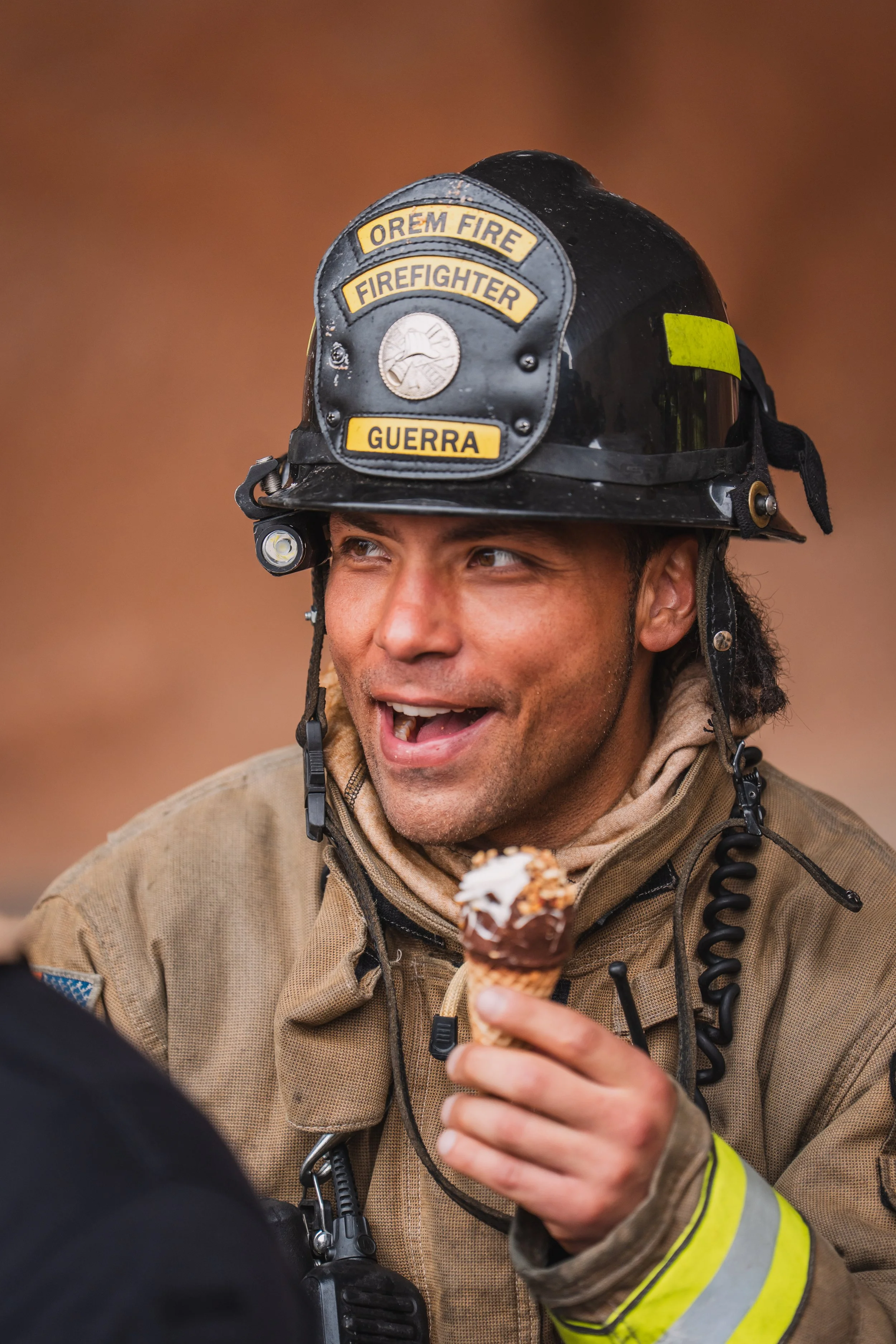 A firefighter enjoys his post scenario ice cream cone.