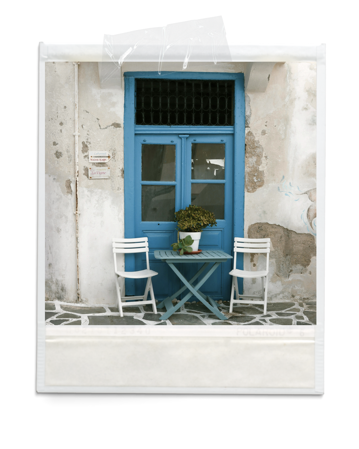 A white patio with a blue door and window frame, two white chairs, a small blue table with a potted plant, and weathered walls with signs.