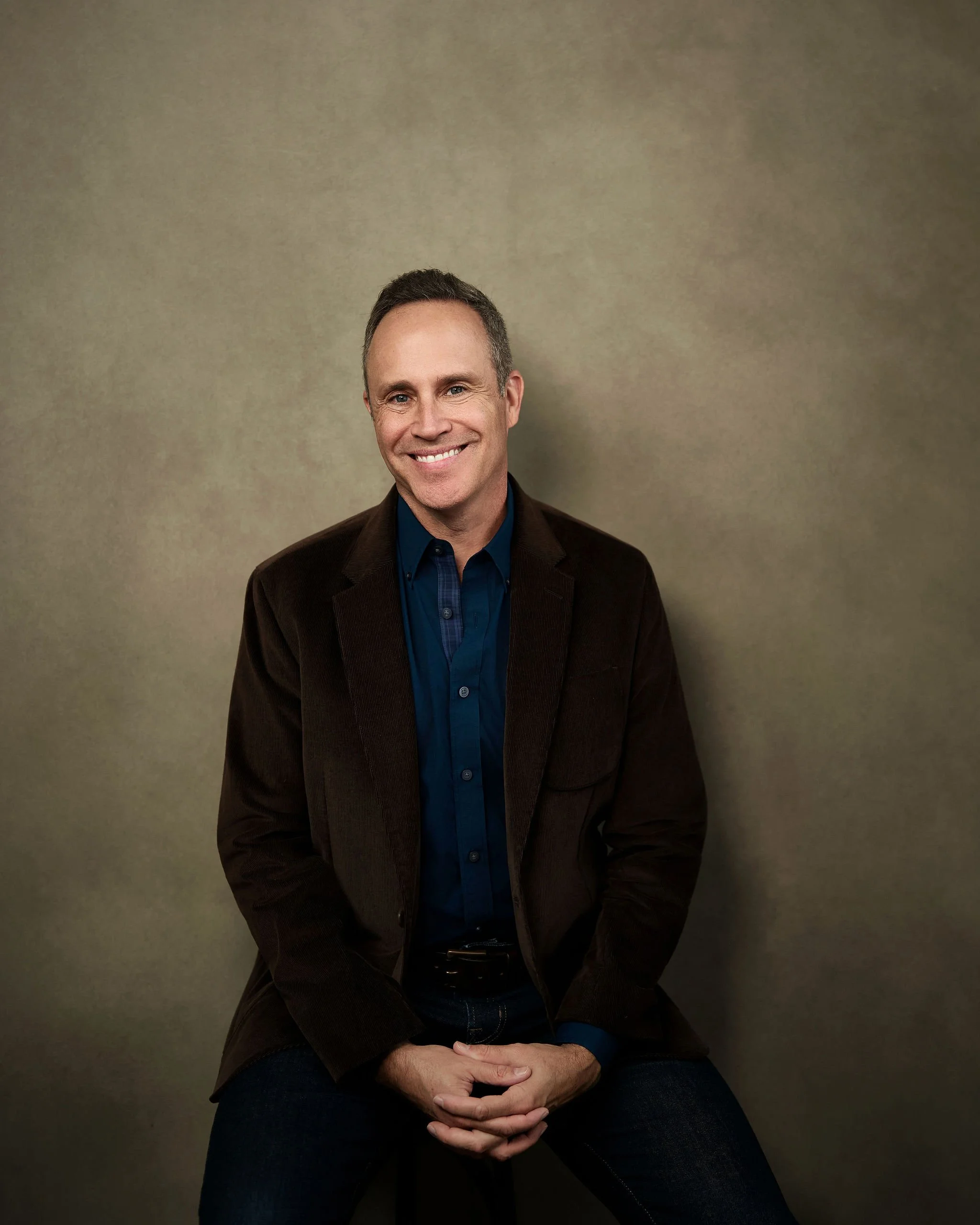 David Bernard, LCSW, New Orleans mental health therapist seated on a stool.