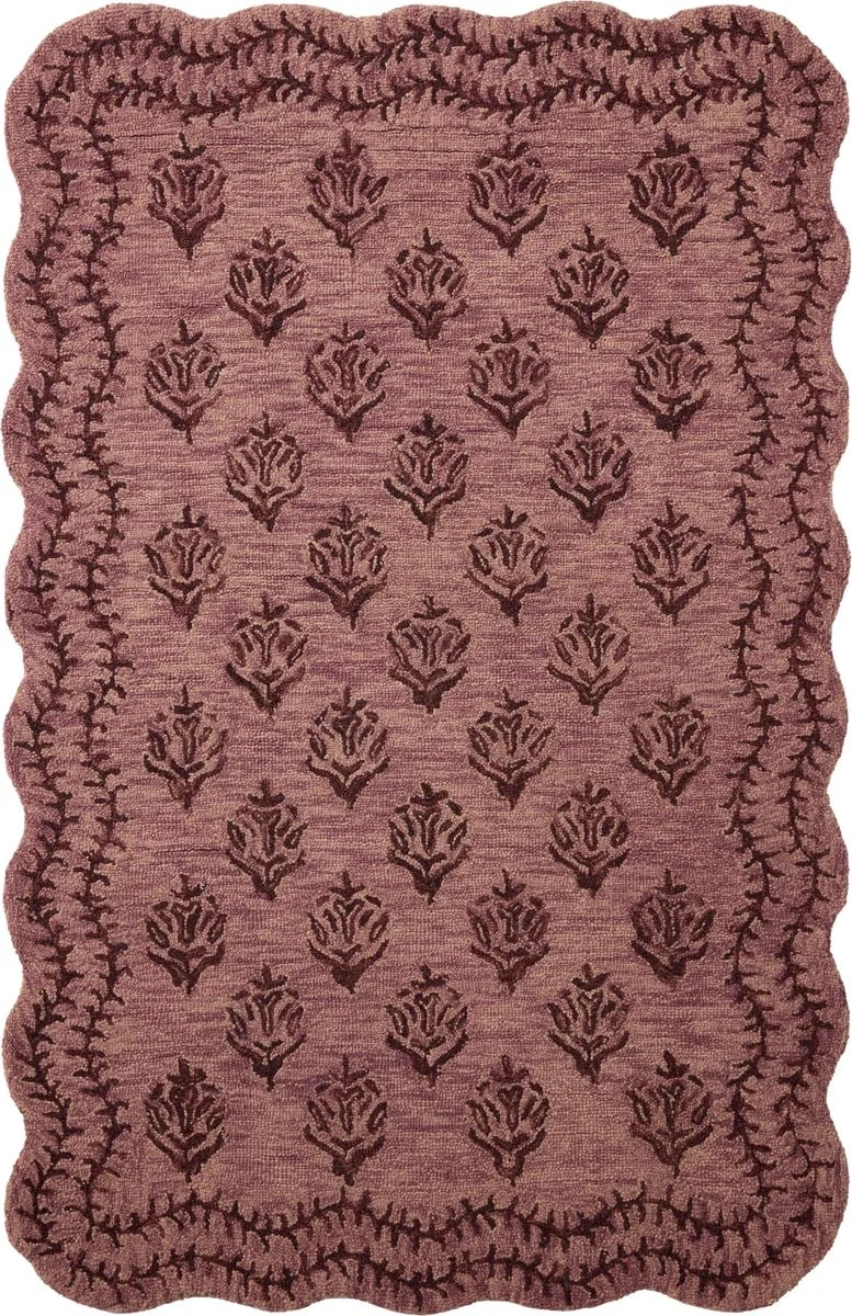 A pinkish-red patterned area rug with dark purple floral motifs and a decorative border.