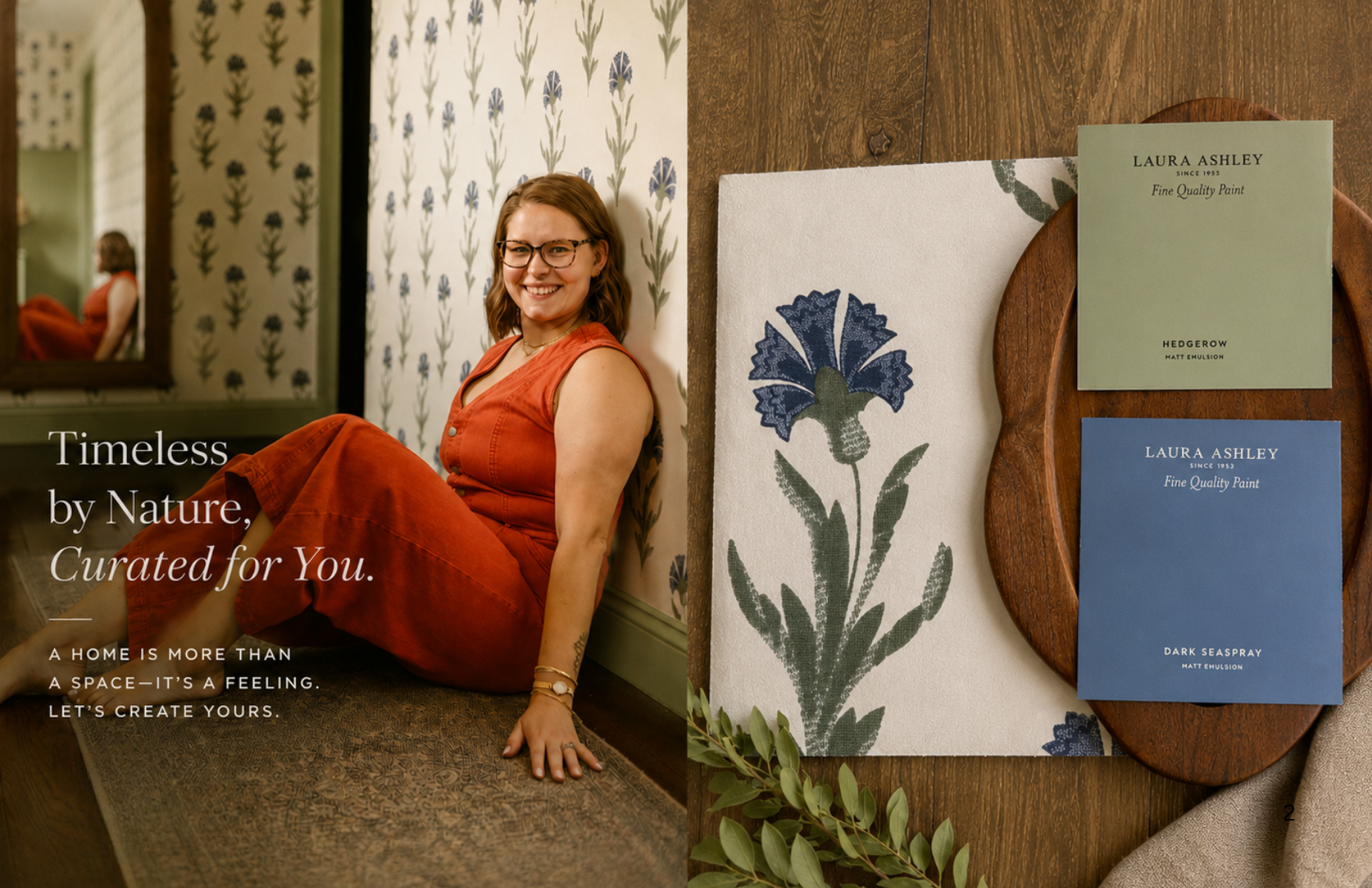 A young woman with glasses and red hair sitting on the floor, smiling. She wears a sleeveless orange dress. Behind her is wallpaper with a floral pattern, and beside her are color swatches and a panel with a floral print, displayed on a wooden surface.