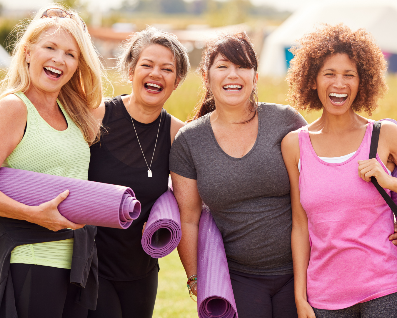 Four strong, happy women in their fifties gathering for outdoor yoga, staying active and healthy through menopause.