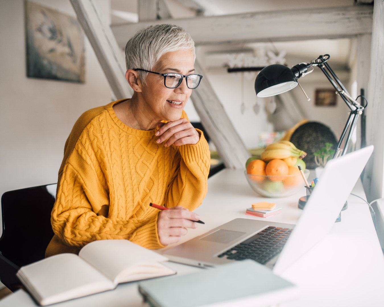 Woman over 50 working at her desk focused for a long period on work without worrying about leaking when she laughs.
