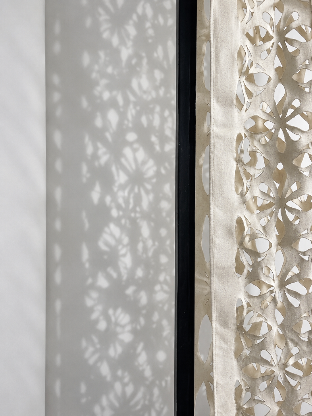 The curtain's pattern draws on shapes and geometric patterns found in the plants themselves, creating an organic aesthetic that maintains a sense of nature even when there is no vegetation growing.