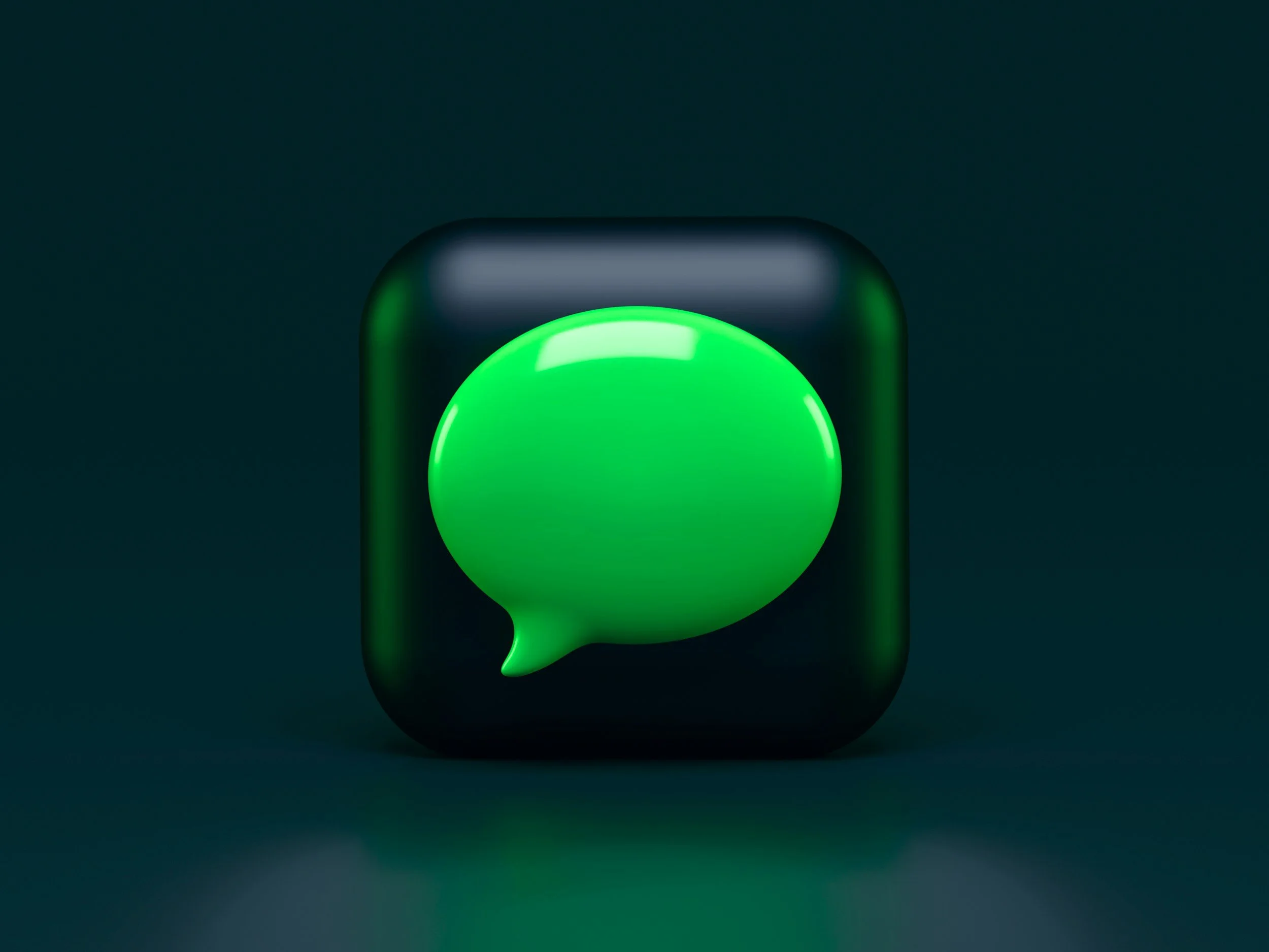 Close-up of a digital green speech bubble icon with a circular shape, glowing edge, set against a dark background.