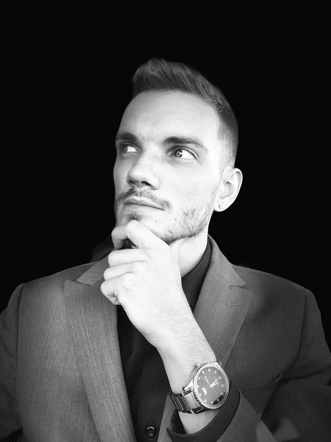 John Schuster Jr., Founder of Schuster's Business Boosters, in a black and white portrait looking thoughtfully upward, representing strategic planning and executive leadership for small business growth.