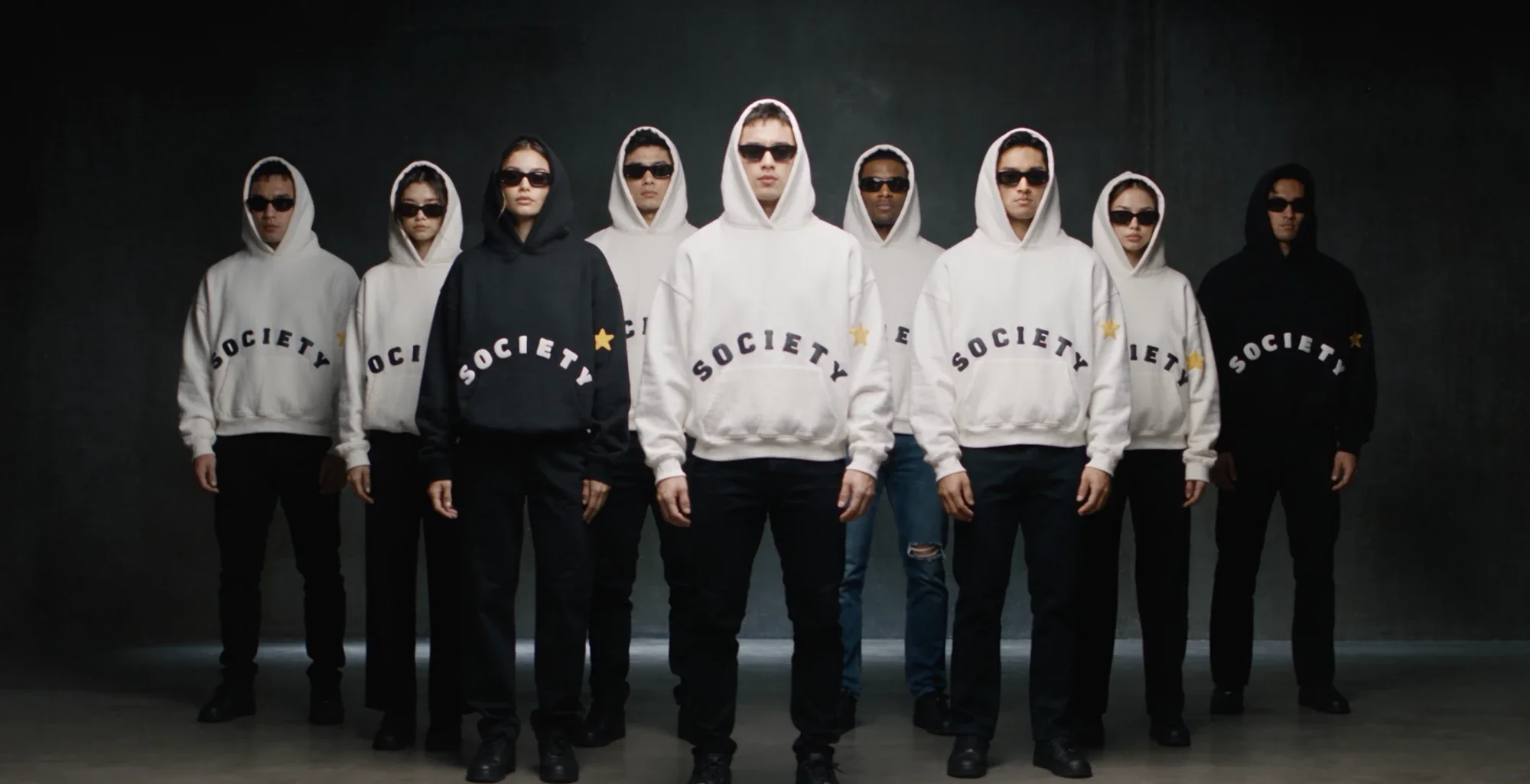 A group wearing The Society hoodies in black and white.