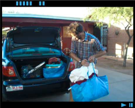 Dan loading bags into the back of a sedan.