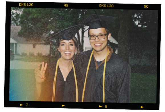 A graduation picture of Dan Wilson standing beside a friend. They're smiling and wearing graduation caps and gowns.