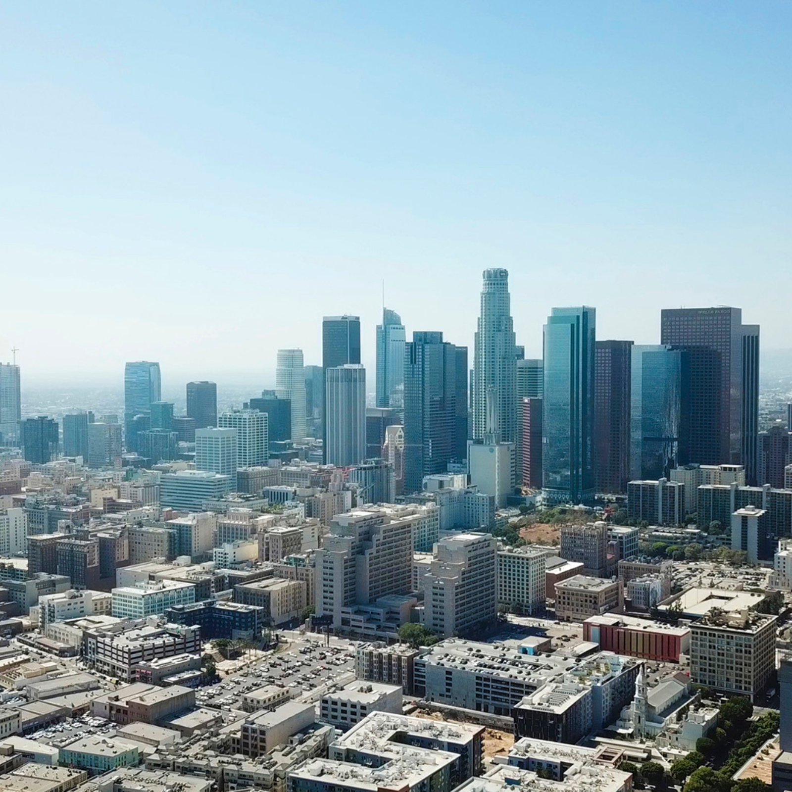 Aerial view of the Los Angeles skyline with tall skyscrapers and a sprawling urban area.