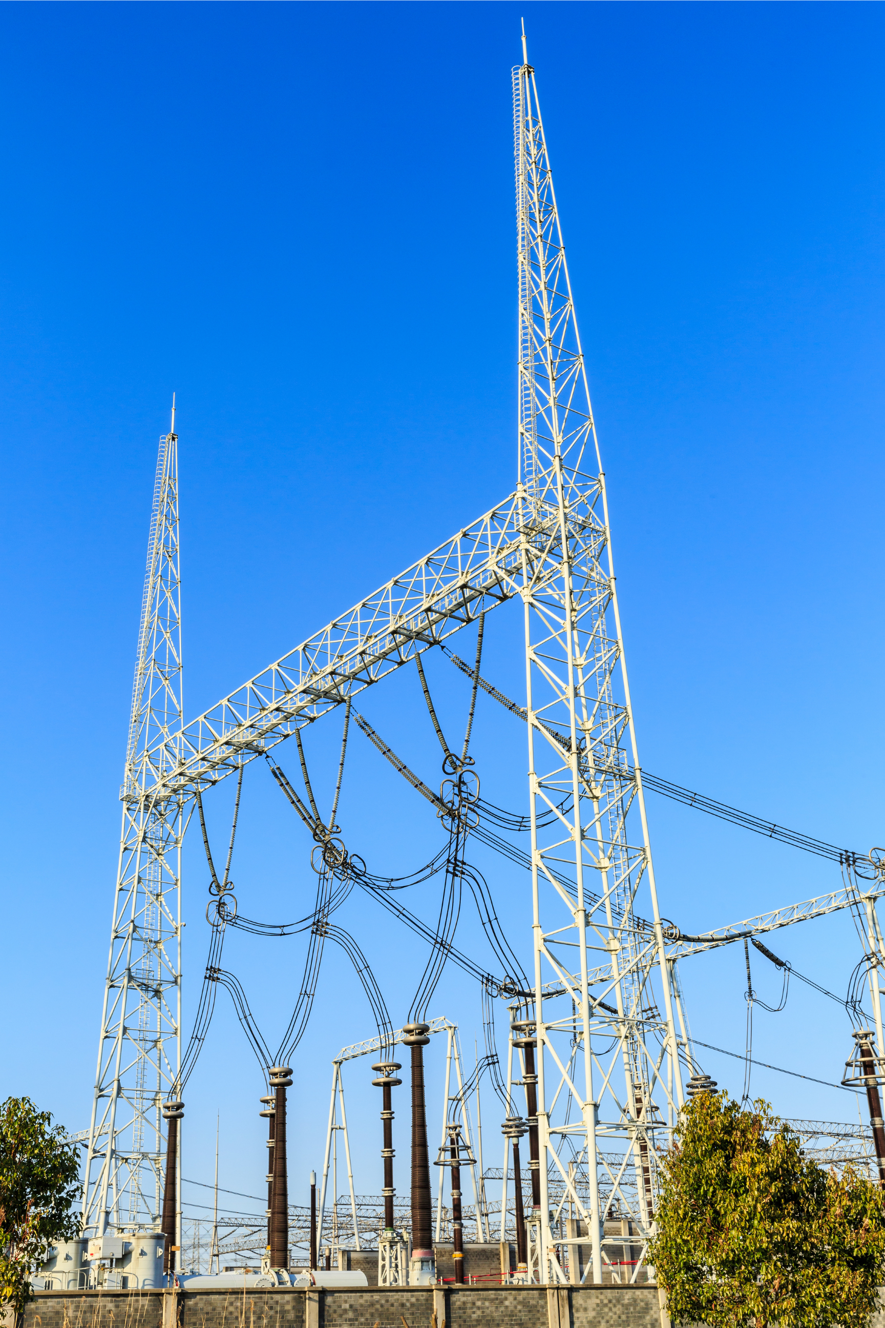 Những cột truyền tải điện và đường dây điện nổi bật trên nền trời xanh trong vắt.