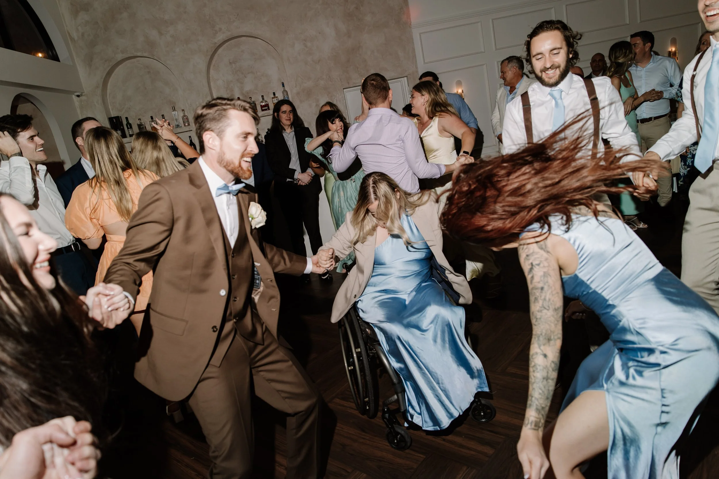 People dancing and enjoying themselves at a social gathering or party in an indoor venue.