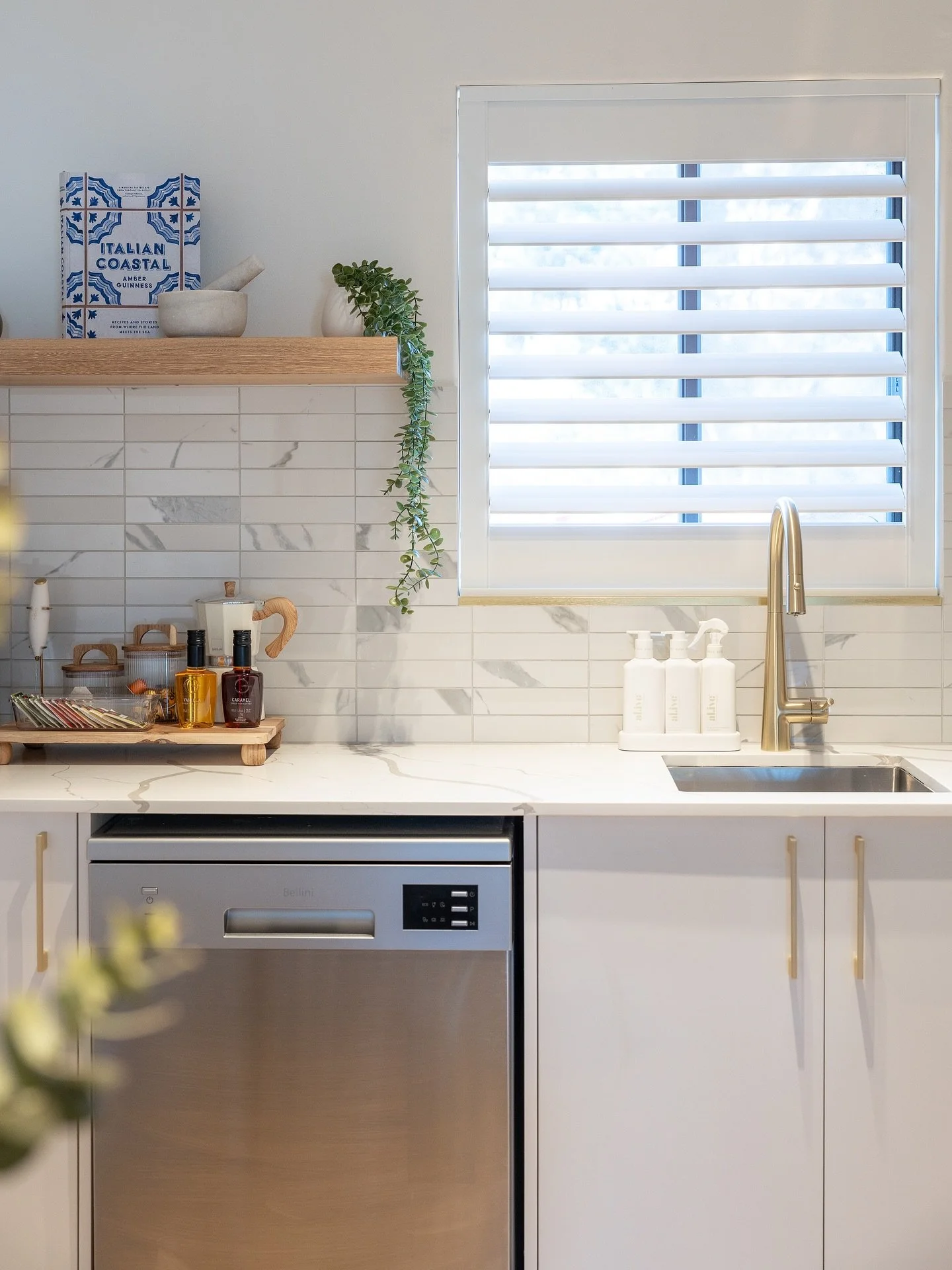 Premium kitchen renovation plumbing showing stone benchtops, gold tapware, and professional appliance installation.