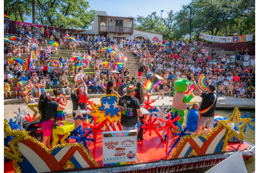 Vibrant parade float and cheering crowd at the Visit San Antonio Pride River Parade, a major San Antonio Pride celebration along the River Walk.