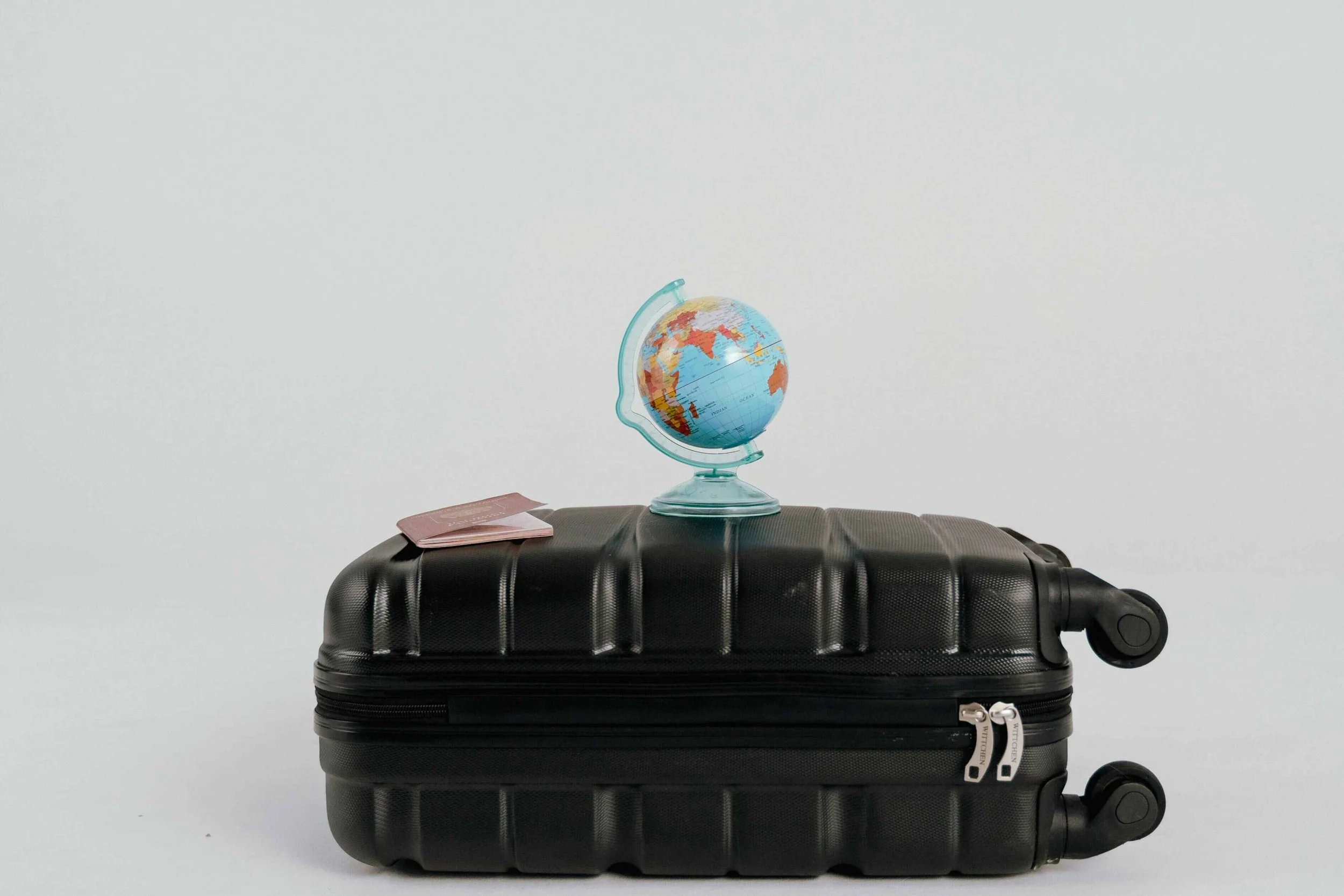 Suitcase with globe and passport representing travel lifestyle and living abroad