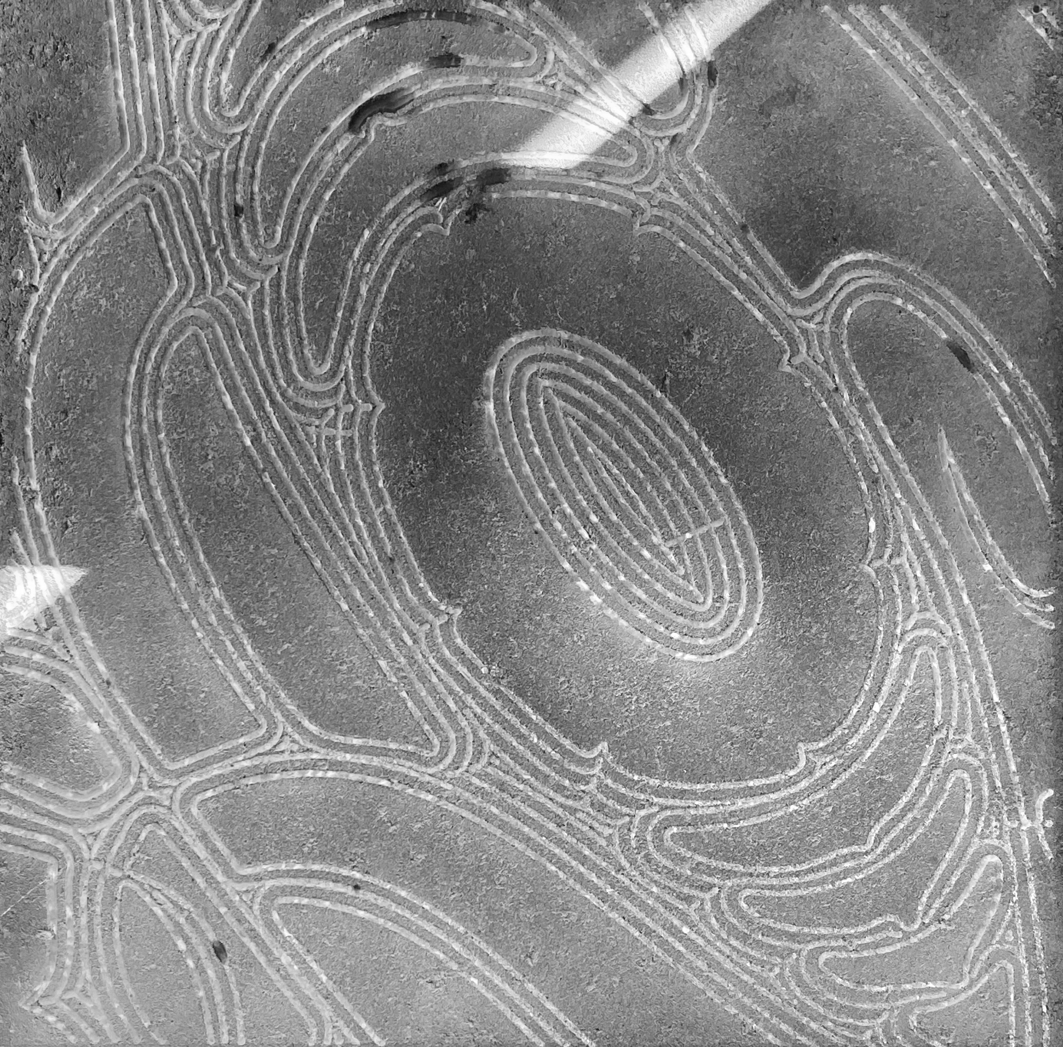 Close-up view of a road with intricate, winding white lane markings on an asphalt surface.