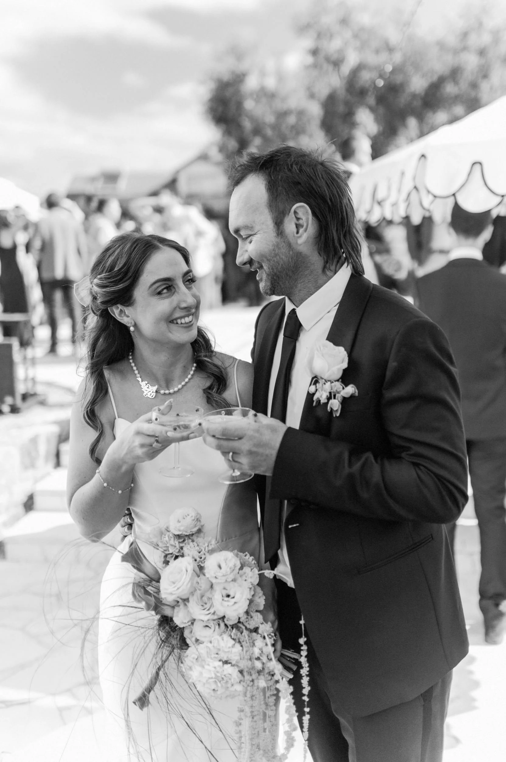 A bride and groom smiling and toasting with drinks at Palazzo Campania, Tasmania