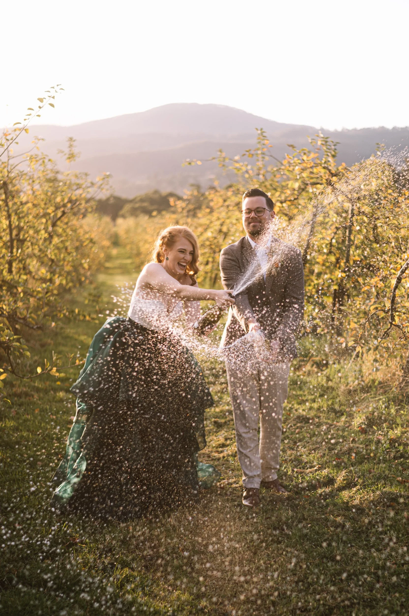 A bride and groom spray champagne in the Huon Valley, Tasmania