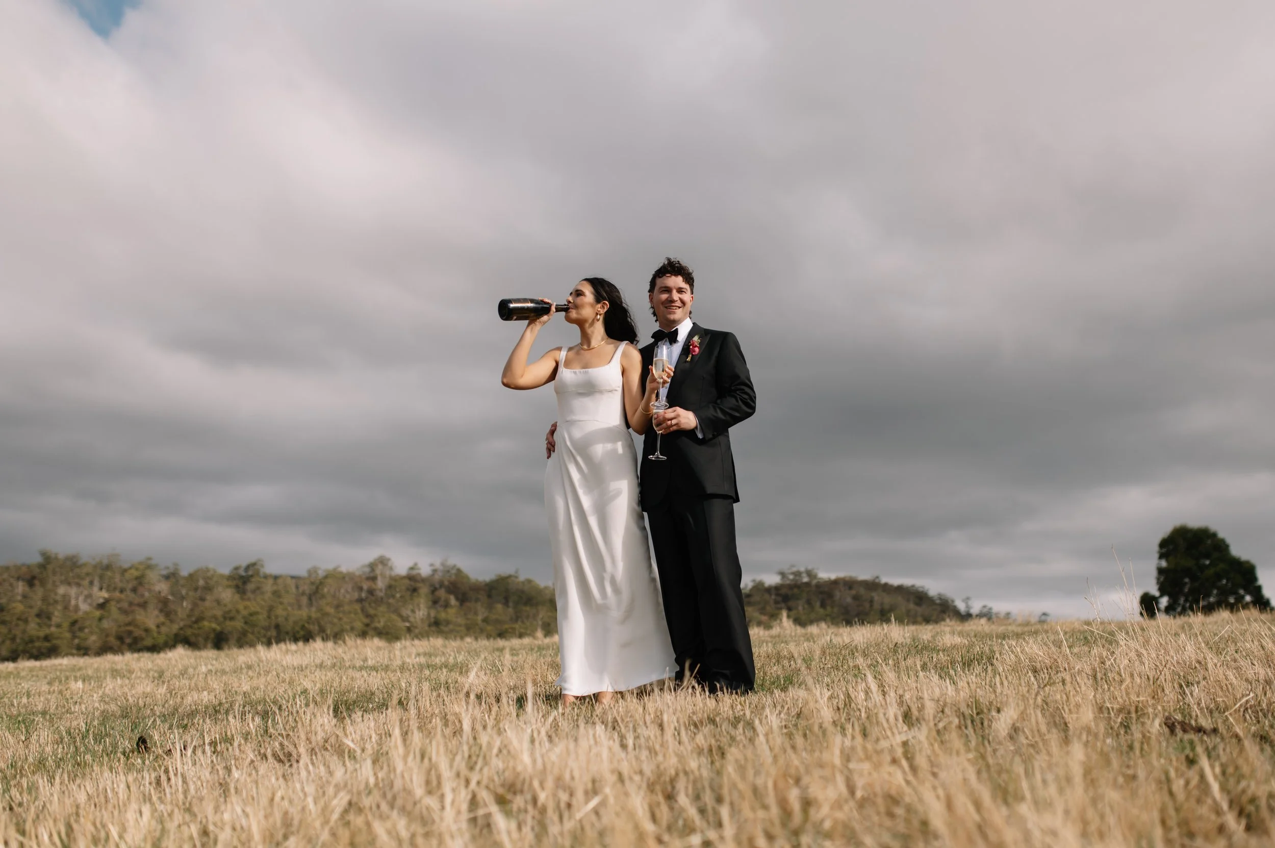 Grace and Matt celebrating in the golden fields at Premaydena Hill Winery, Tasman Peninsula - Jonathan Wherrett - wedding photographer - Tasmania