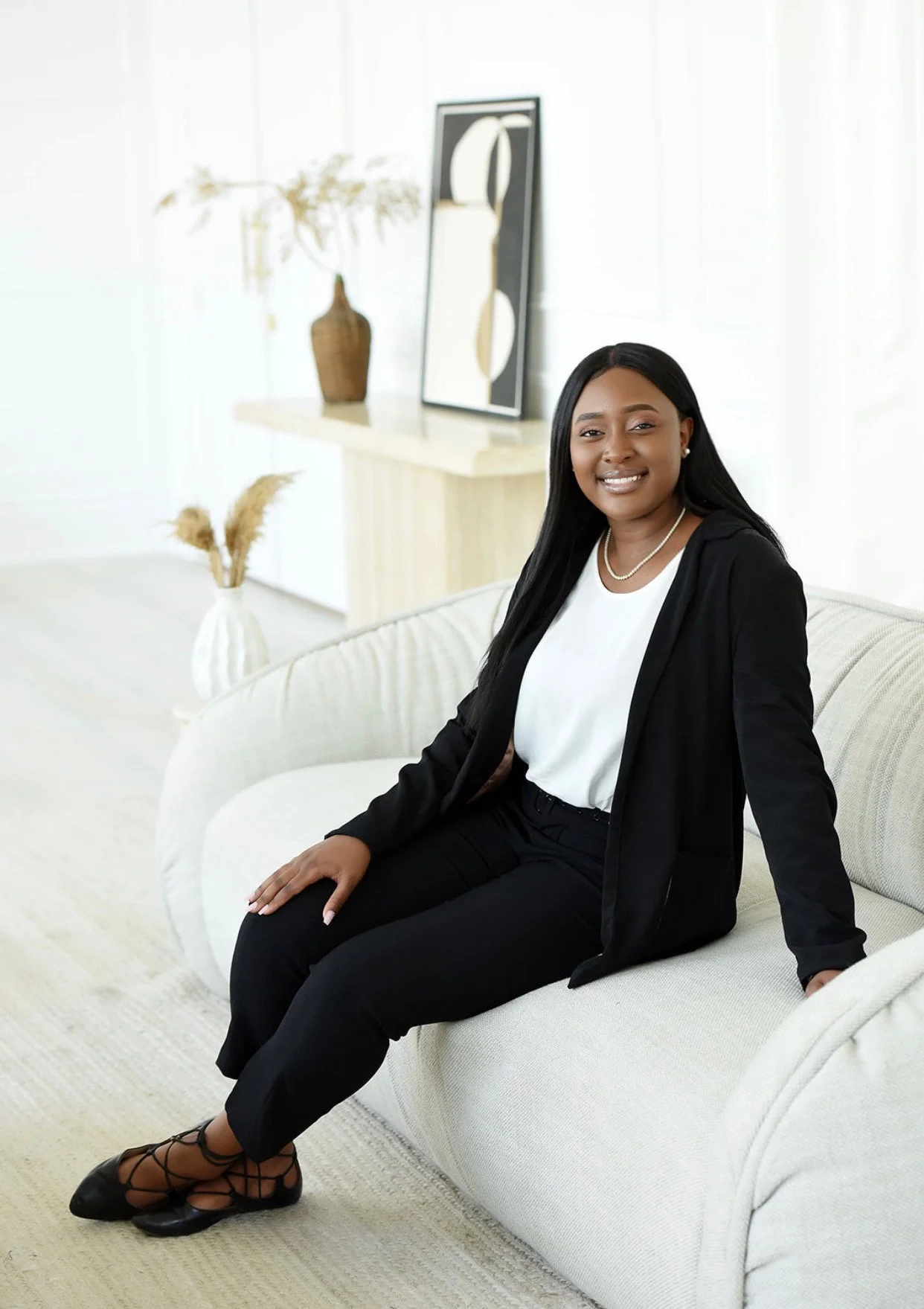 Davina Mukinav registered social worker and therapist, sitting in a bright living room, offering a calm and approachable presence.