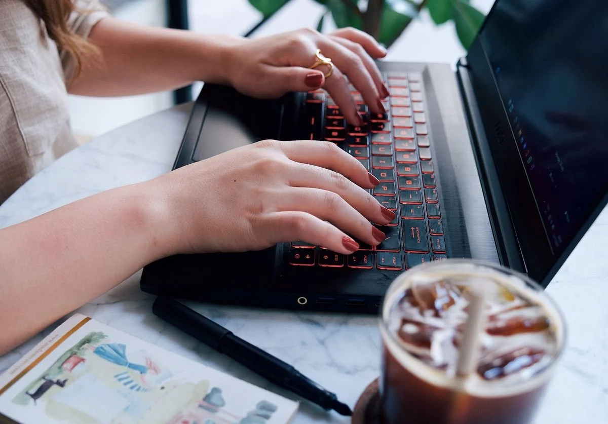 woman-typing-on-laptop-with-iced-coffee-nearby.jpg