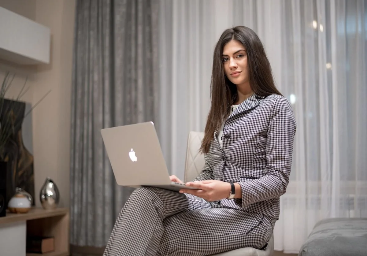 business-woman-typing-on-laptop-and-looking-into-camera.jpg