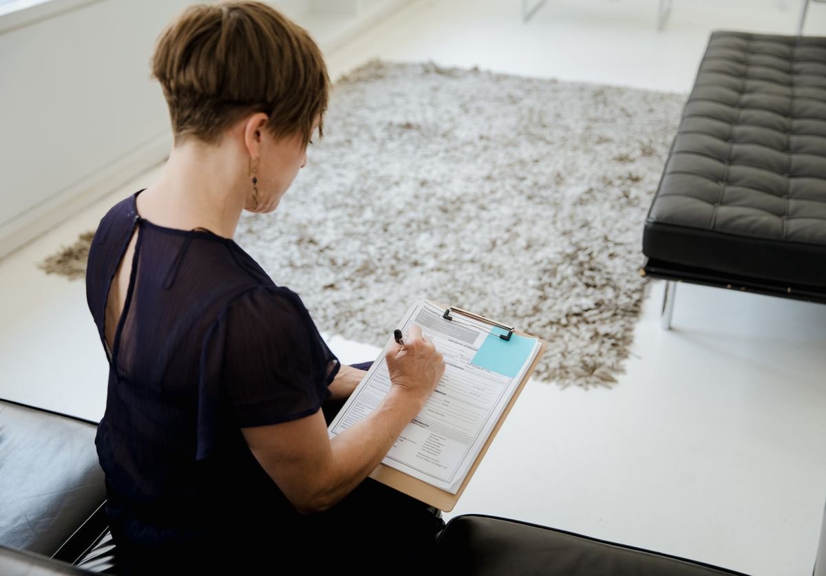 a-woman-taking-notes-in-private-practice-wellness-nomadic-virtual-solutions.jpg