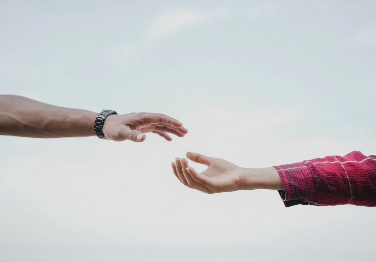 two-hands-reaching-out-to-support-each-other-with-wellness-nomadic-virtual-solutions.jpg