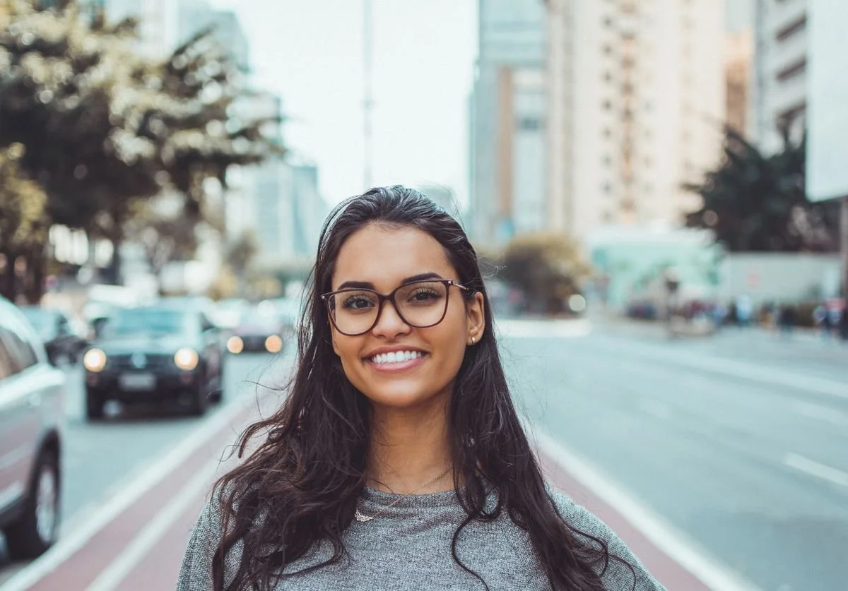 woman-smiling-standing-in-the-middle-of-street-wellness.jpg
