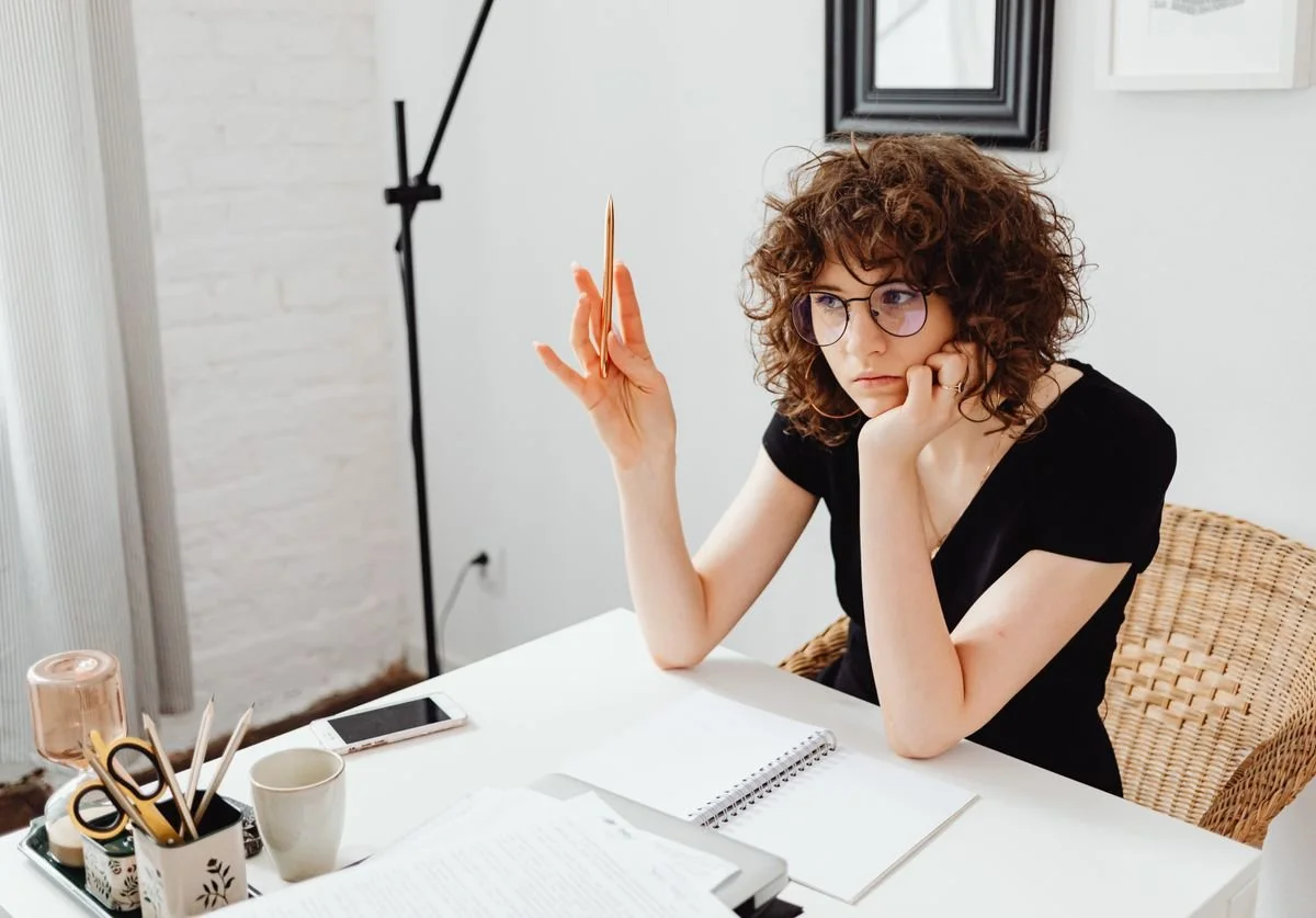 woman-at-a-table-thinking-in-a-bright-and-airy-room.jpg