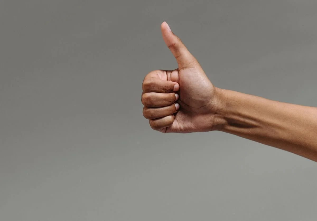 a-thumbs-up-against-a-gray-background.jpg