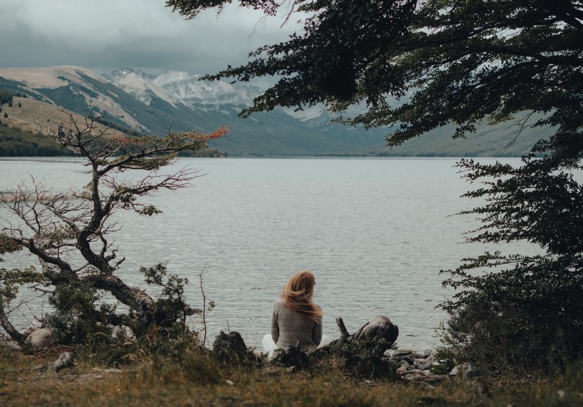 woman-looking-out-at-beautiful-lake-mountains-thinking.jpg