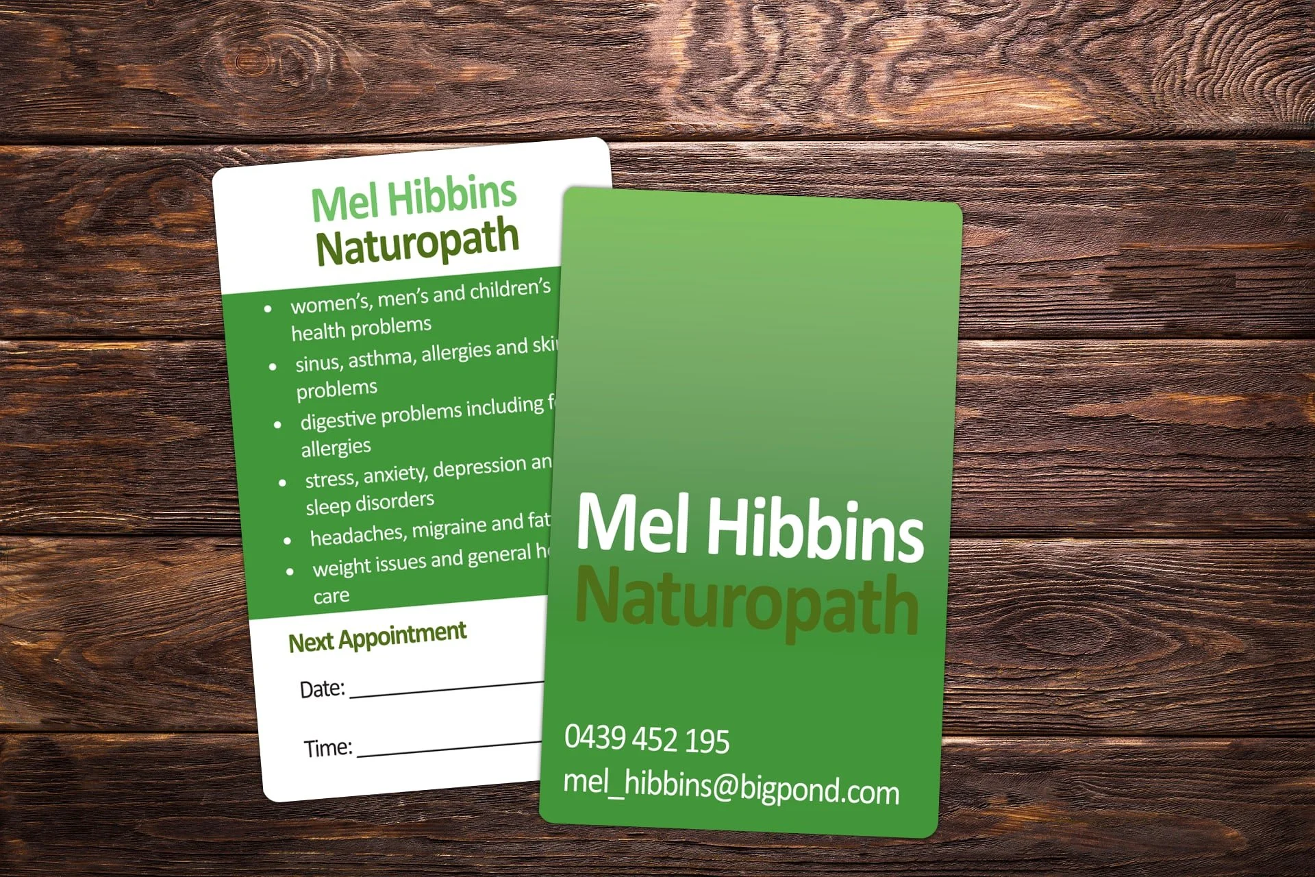 Business card and flyer for Mel Hibbins Naturopath with contact info and services listed, placed on a wooden surface.