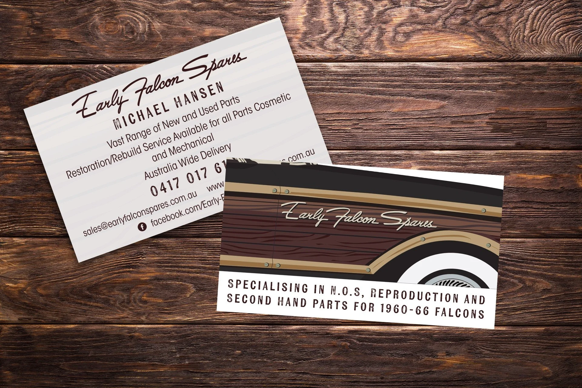 Two business cards on a wooden surface. The cards are for Early Falcon Spares, a company specializing in N.O.S. reproduction and second-hand parts for 1960-66 Falcons. One card has the business name in cursive, while the other provides contact detail