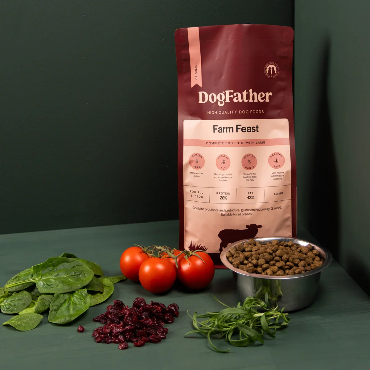 Förpackning av DogFather Farm Feast torrfoder med tomater, spenat, torkad nässla, torkade bär, en skål med hundmat och en sked med hundmat.