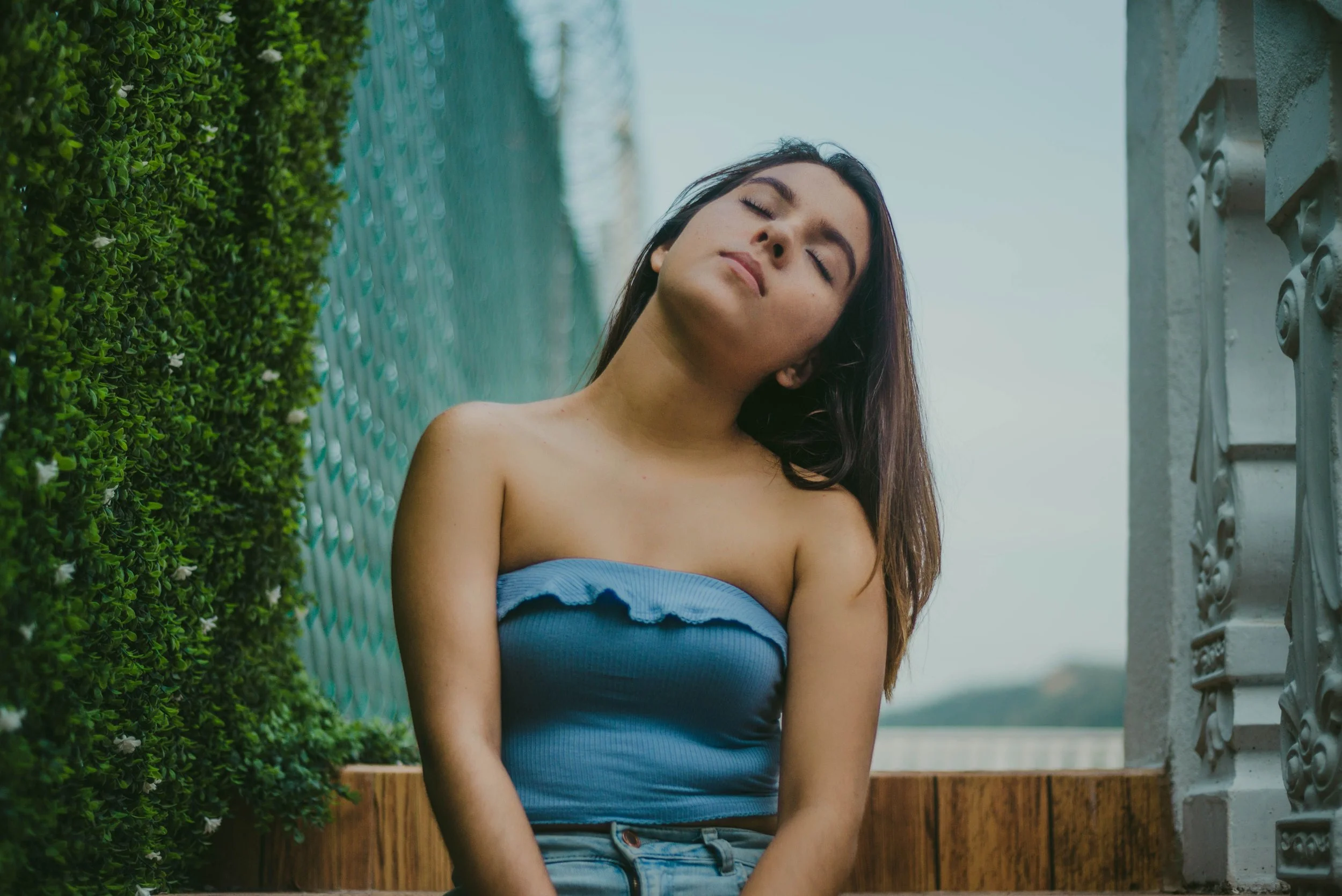 college student sitting outside with eyes closed looking calm and present