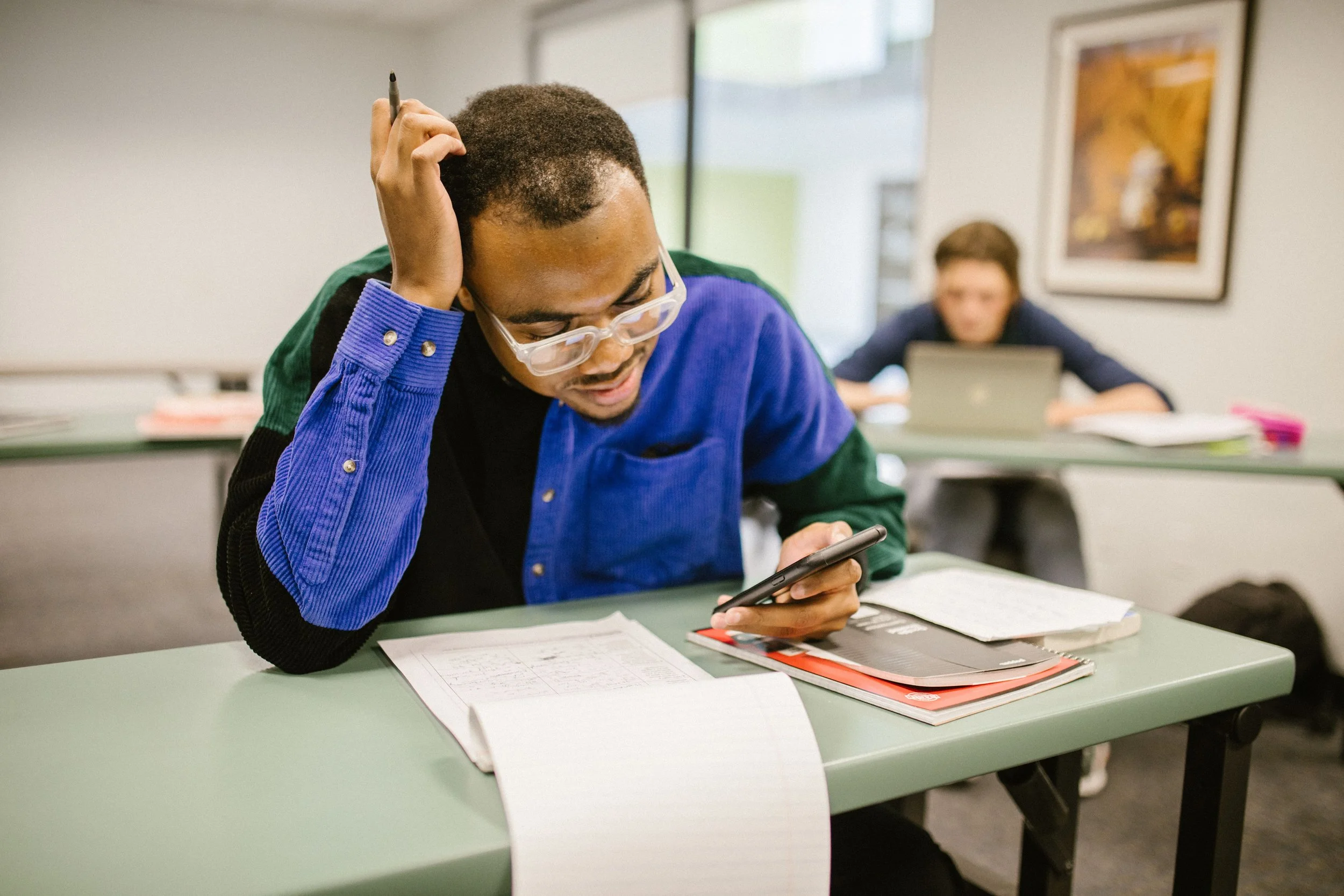 college student looking at phone during lecture