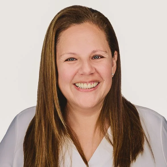 Headshot of smiling female tutor with short blonde hair wearing a lanyard.