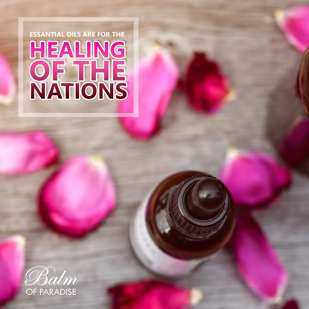 A small brown essential oil bottle surrounded by pink and red rose petals on a wooden surface.