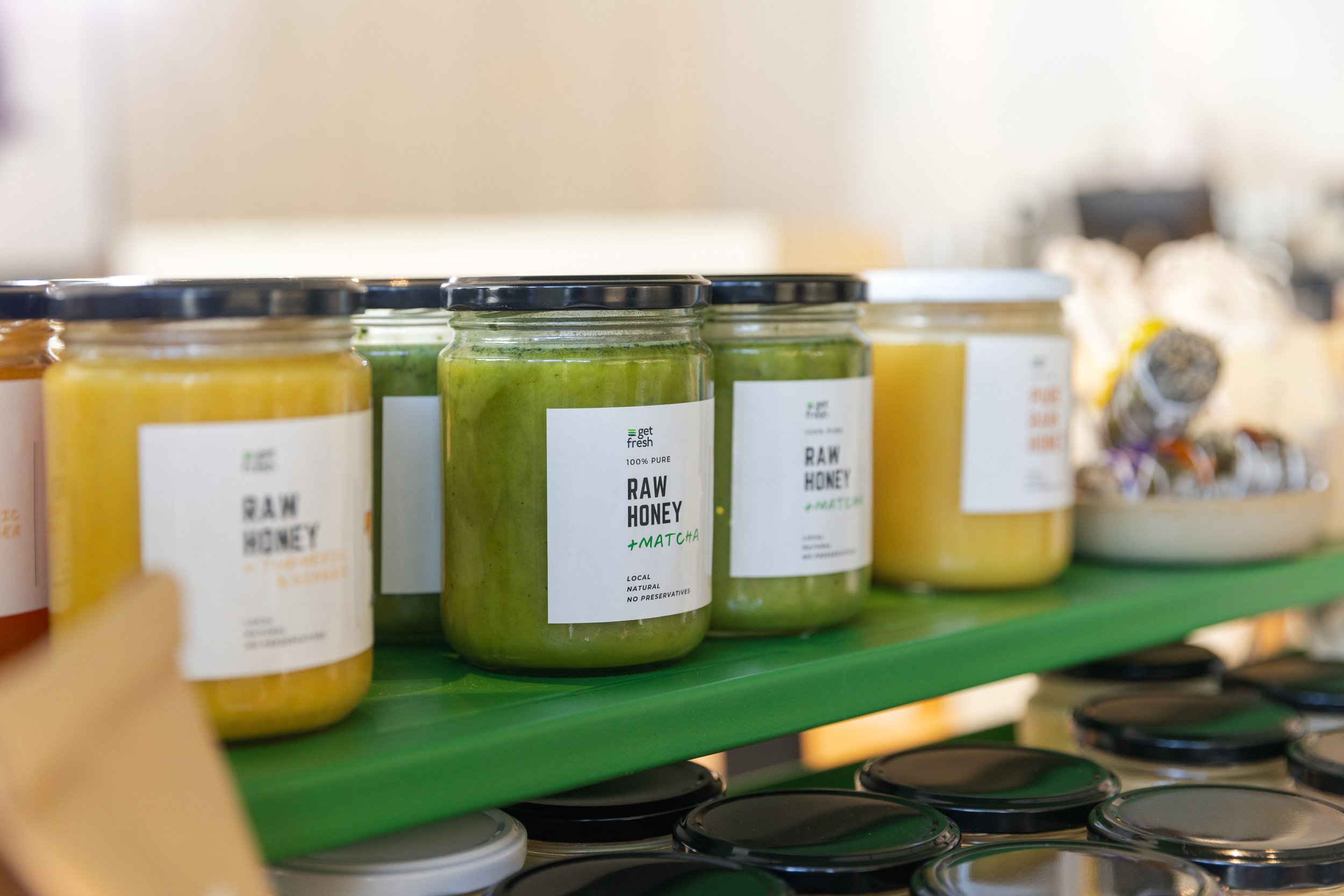 Jars of raw honey and matcha honey in Get Fresh shop shelf.