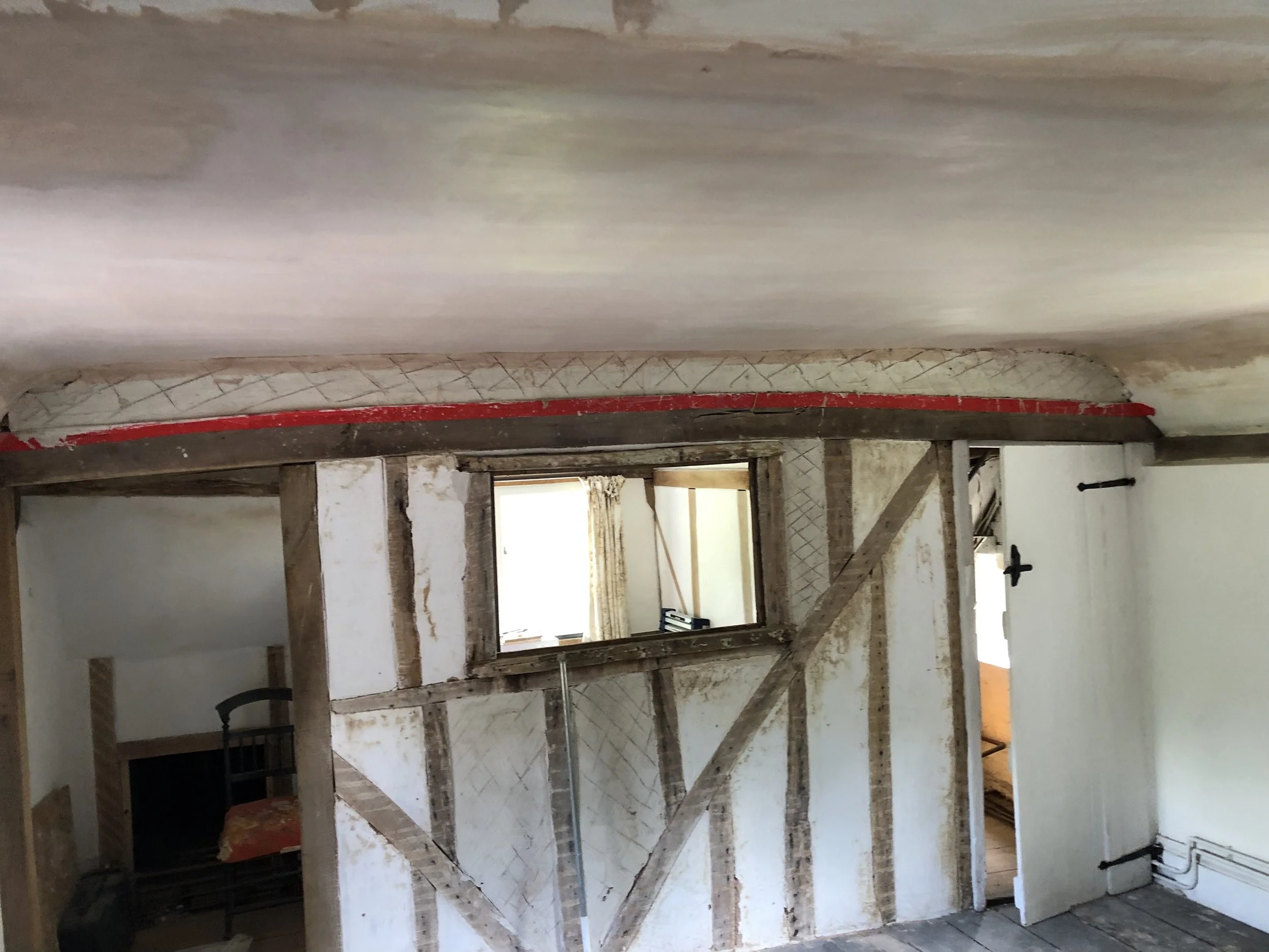 A room under Lime refurbishment with exposed wooden framing, a small window, and construction tools present.
