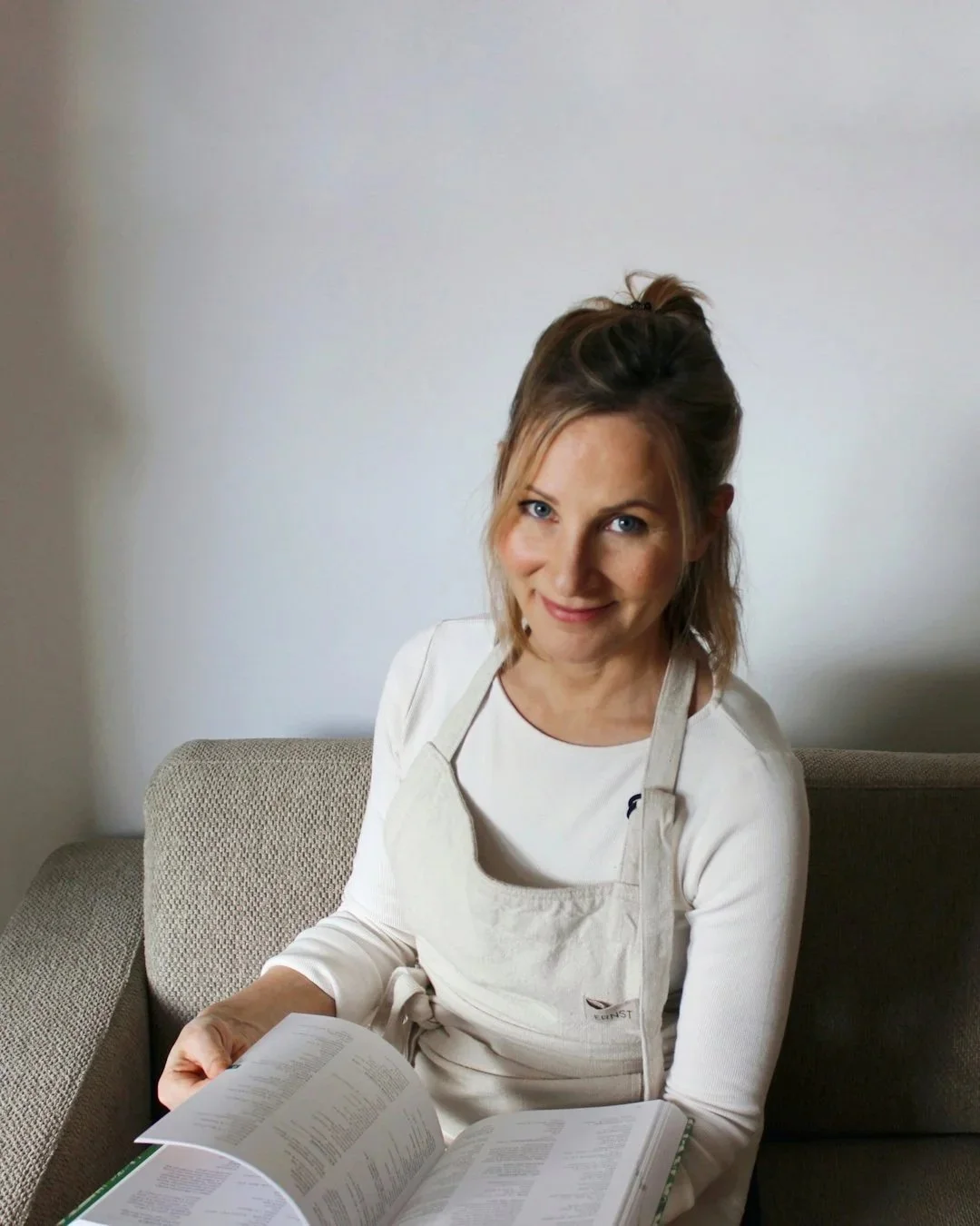 Person mit Schürze auf Sofa sitzend