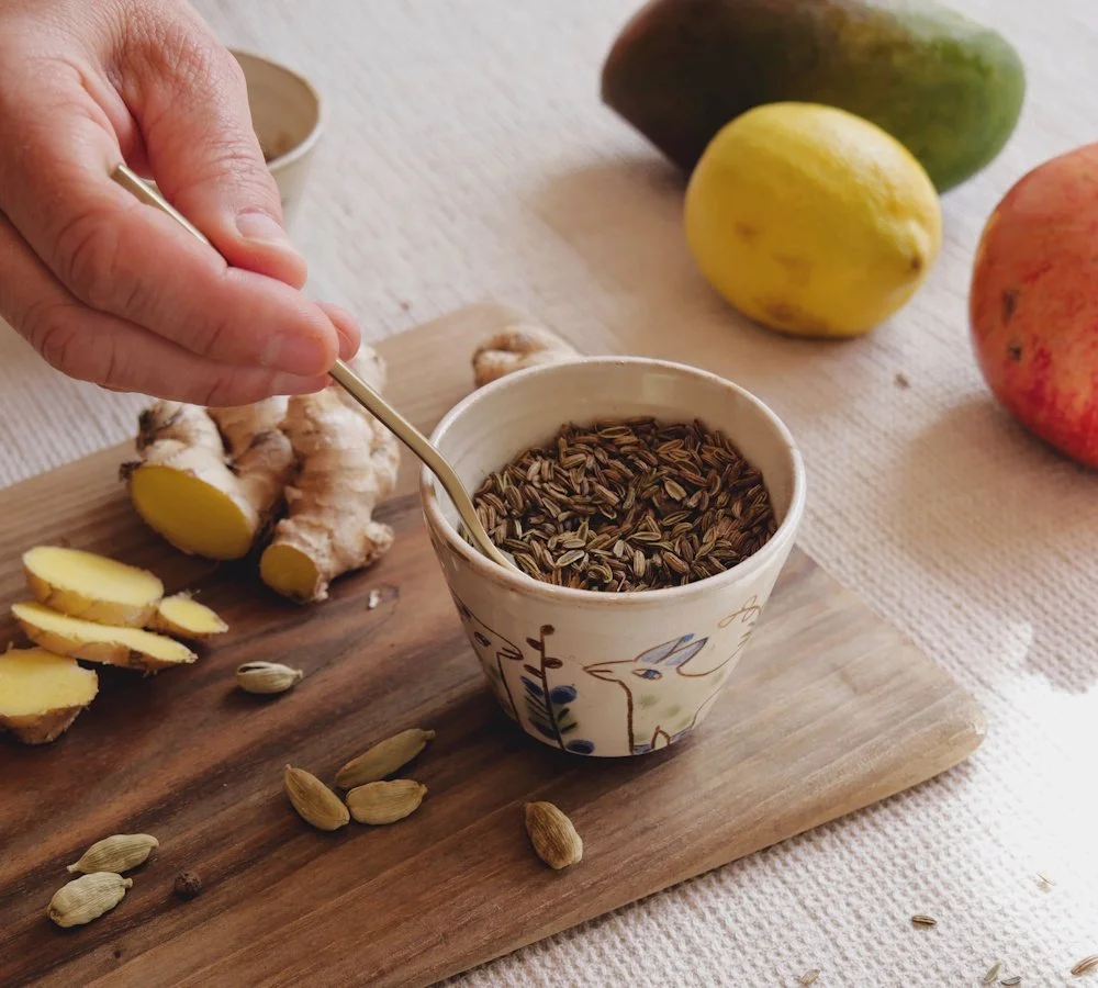 Ayurvedische Gewürze mit frischem Ingwer und Hand