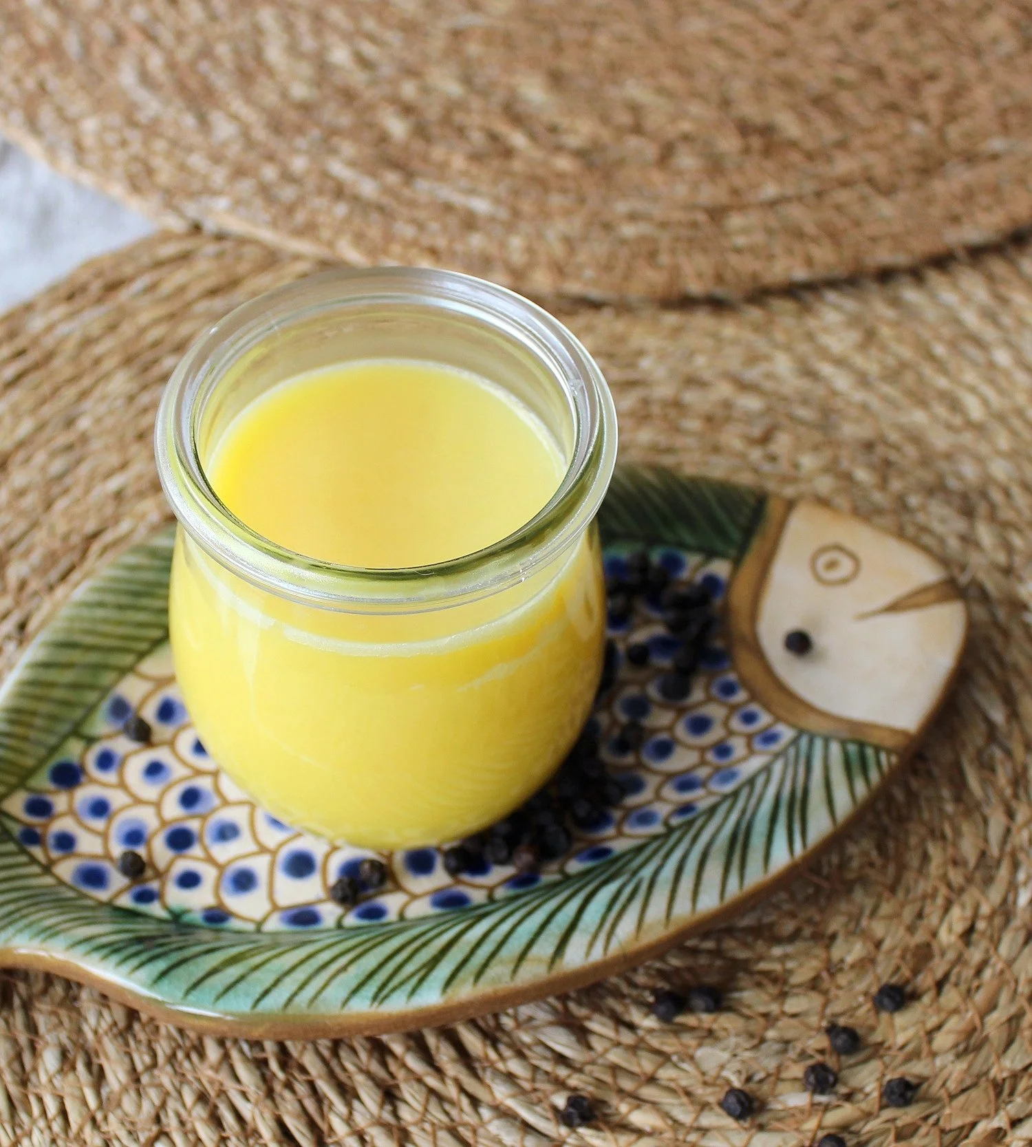 Ayurvedisches Ghee im Glas auf Keramikschale