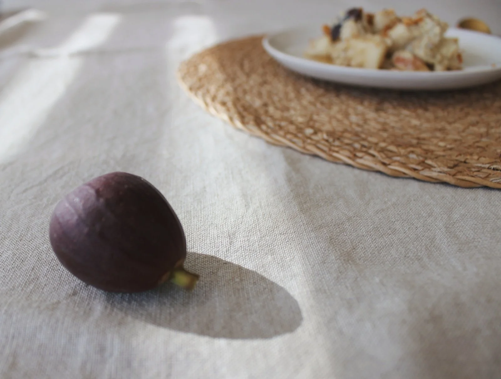 Feige auf Leinentuch mit Porridge im Hintergrund