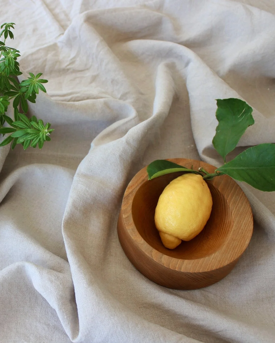 Amalfi-Zitrone in einer Holzschale auf Leinentuch