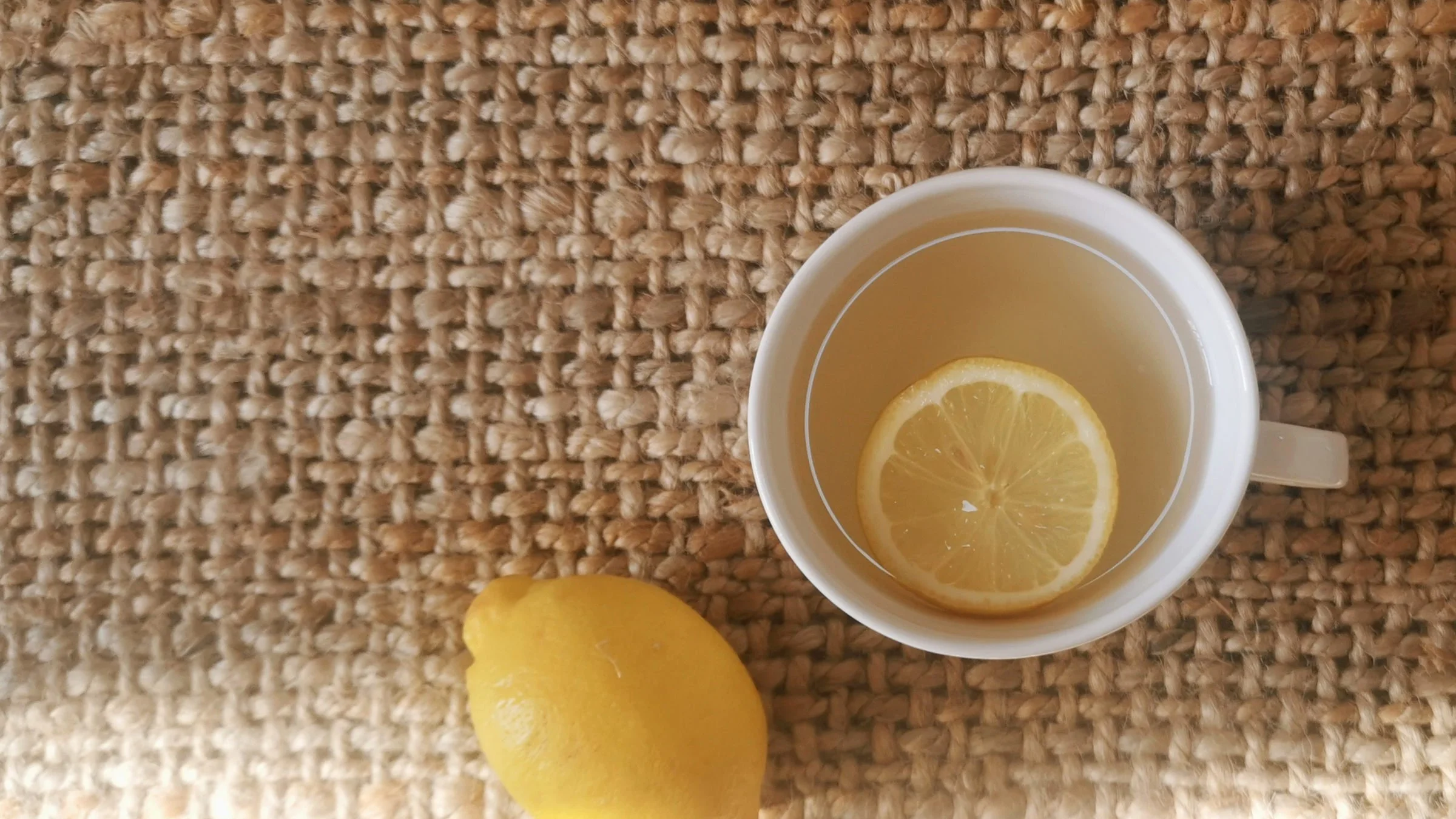 Tasse mit heissem Wasser und Zitrone