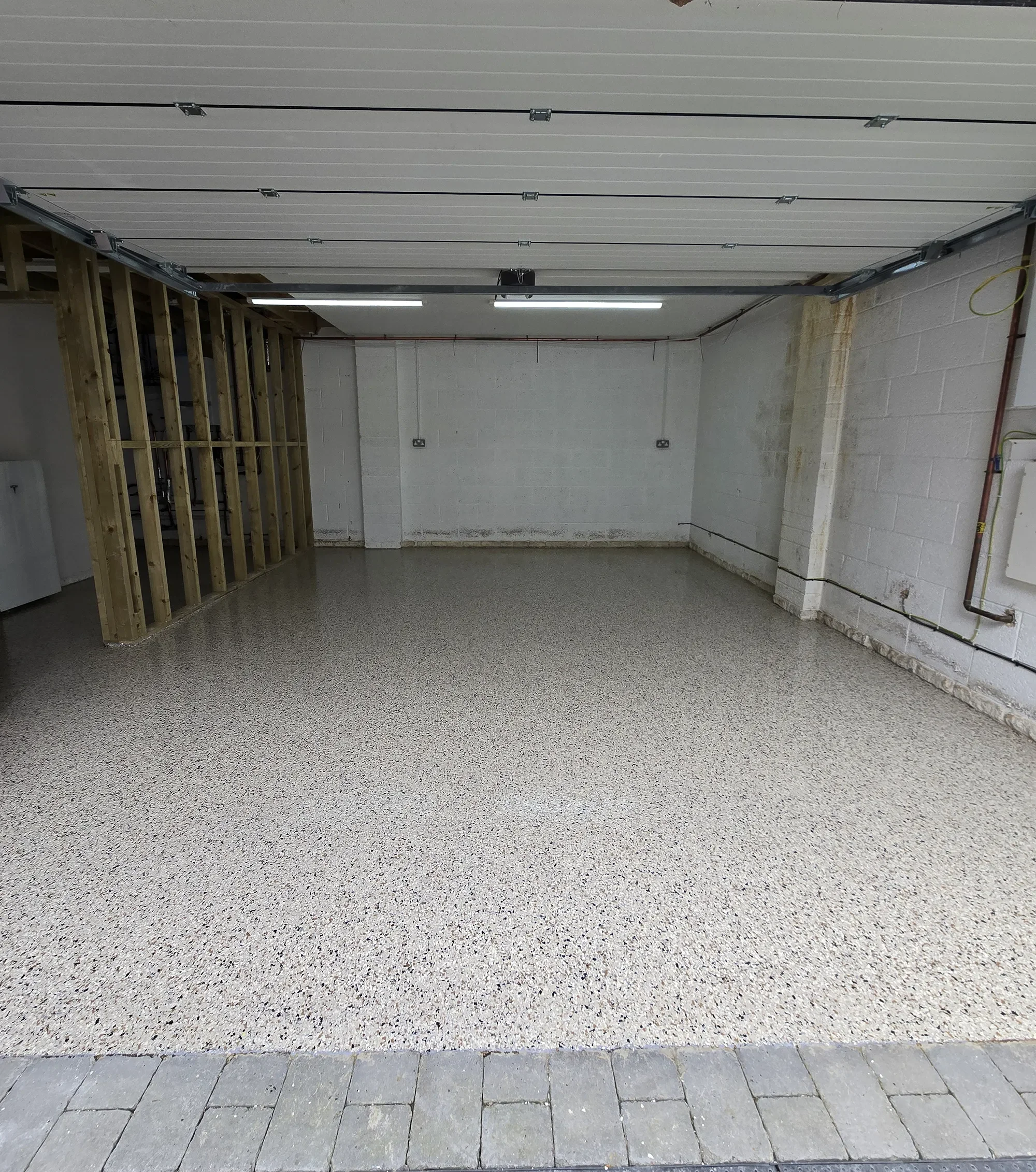 Empty garage with a speckled resin floor.